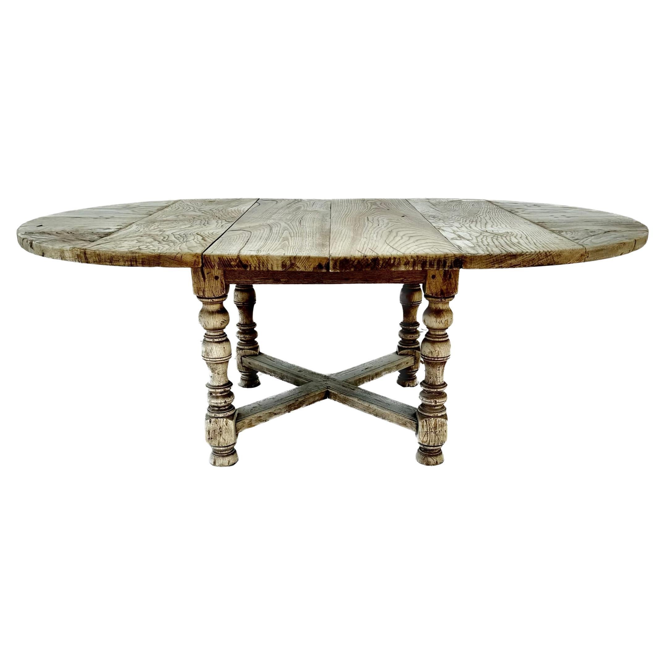 Early 20th century rustic thick bleached oak round dining room table. Table features thick solid bleached wood top with two 12.5 inch leaves (total of 25