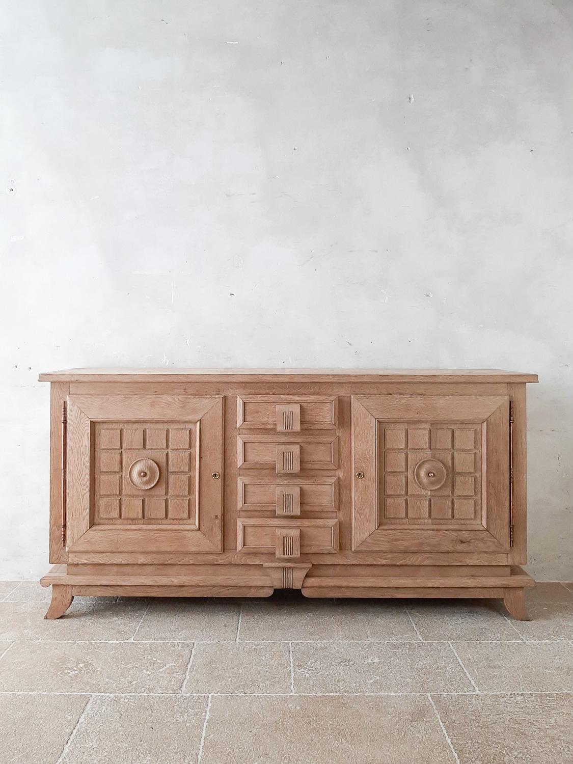 Bleached oak vintage credenza by Charles Dudouyt from the 1940s. Stunning midcentury sideboard with two paneled doors with the typical geometrical shapes of Charles Dudouyt and 4 drawers with wooden handles that are incorporated within the design.