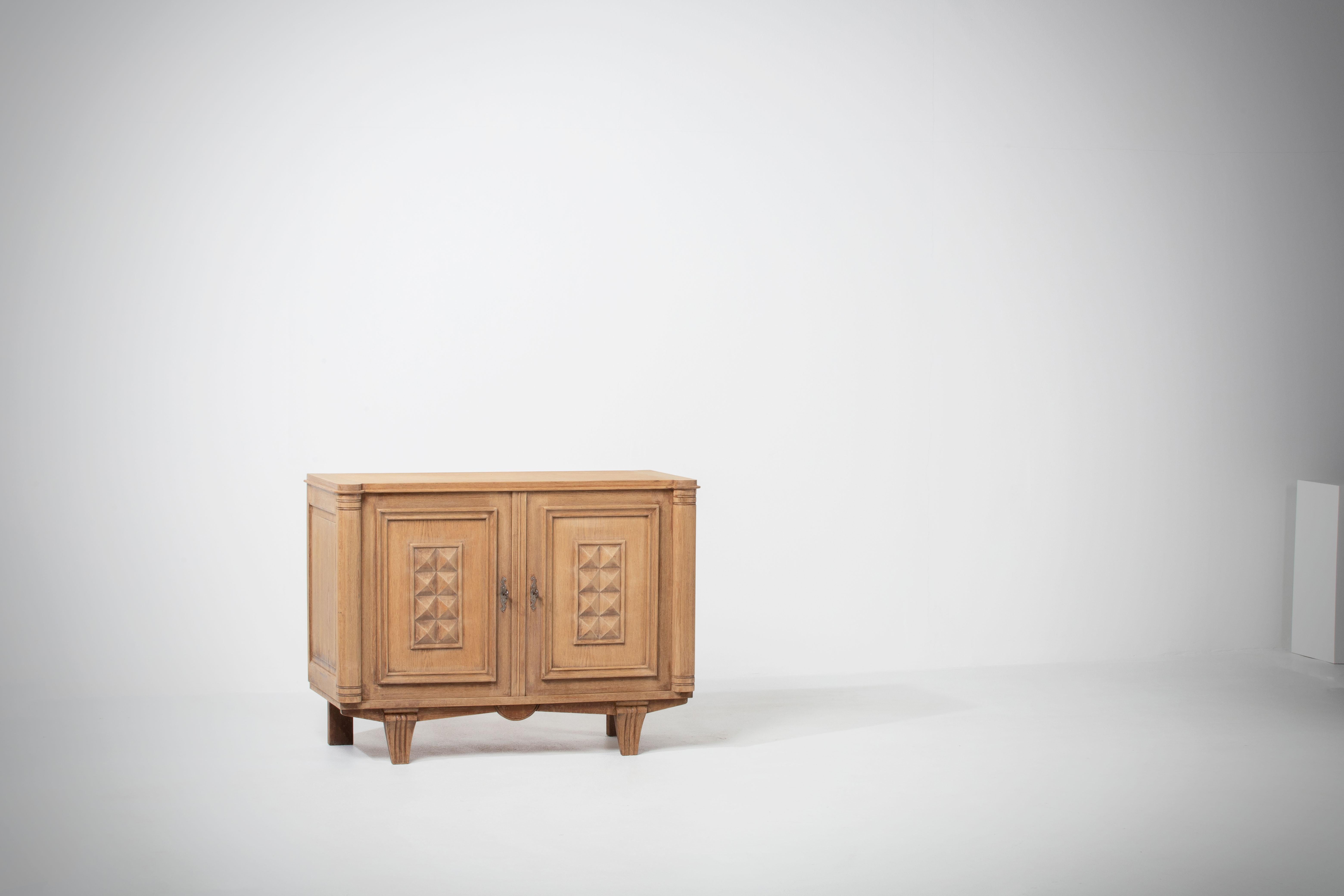 Credenza, solid oak, France, 1940s
Art Deco Brutalist sideboard. 
The credenza consists of two storage facilities and covered with very detailed designed doors. 
 