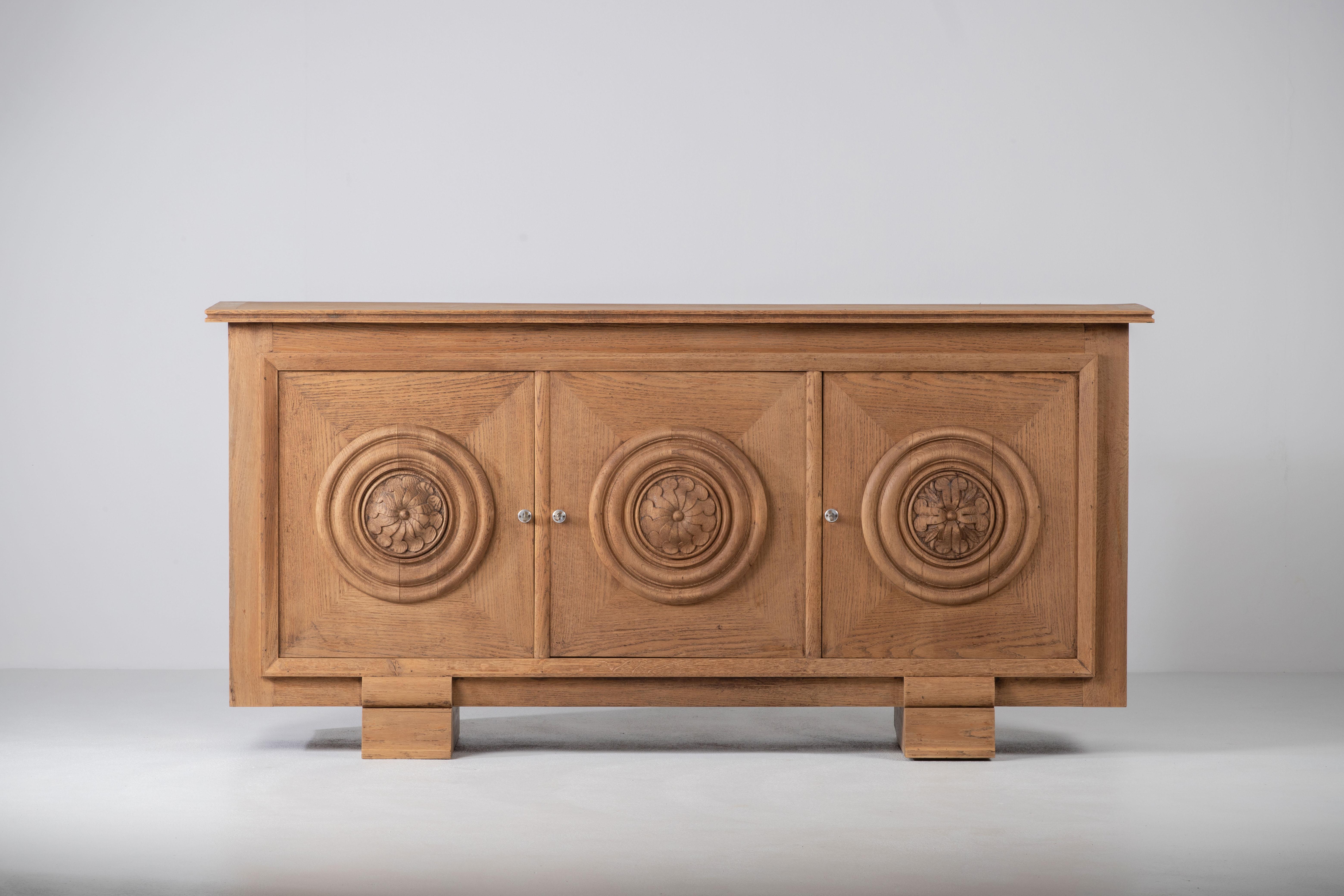 Very elegant Credenza in solid oak, France, 1940s.
Large Art Deco Brutalist sideboard. 
The credenza consists of three storage facilities and covered with very detailed designed doors. 
Very elegant 
The refined wooden structures on the doors create