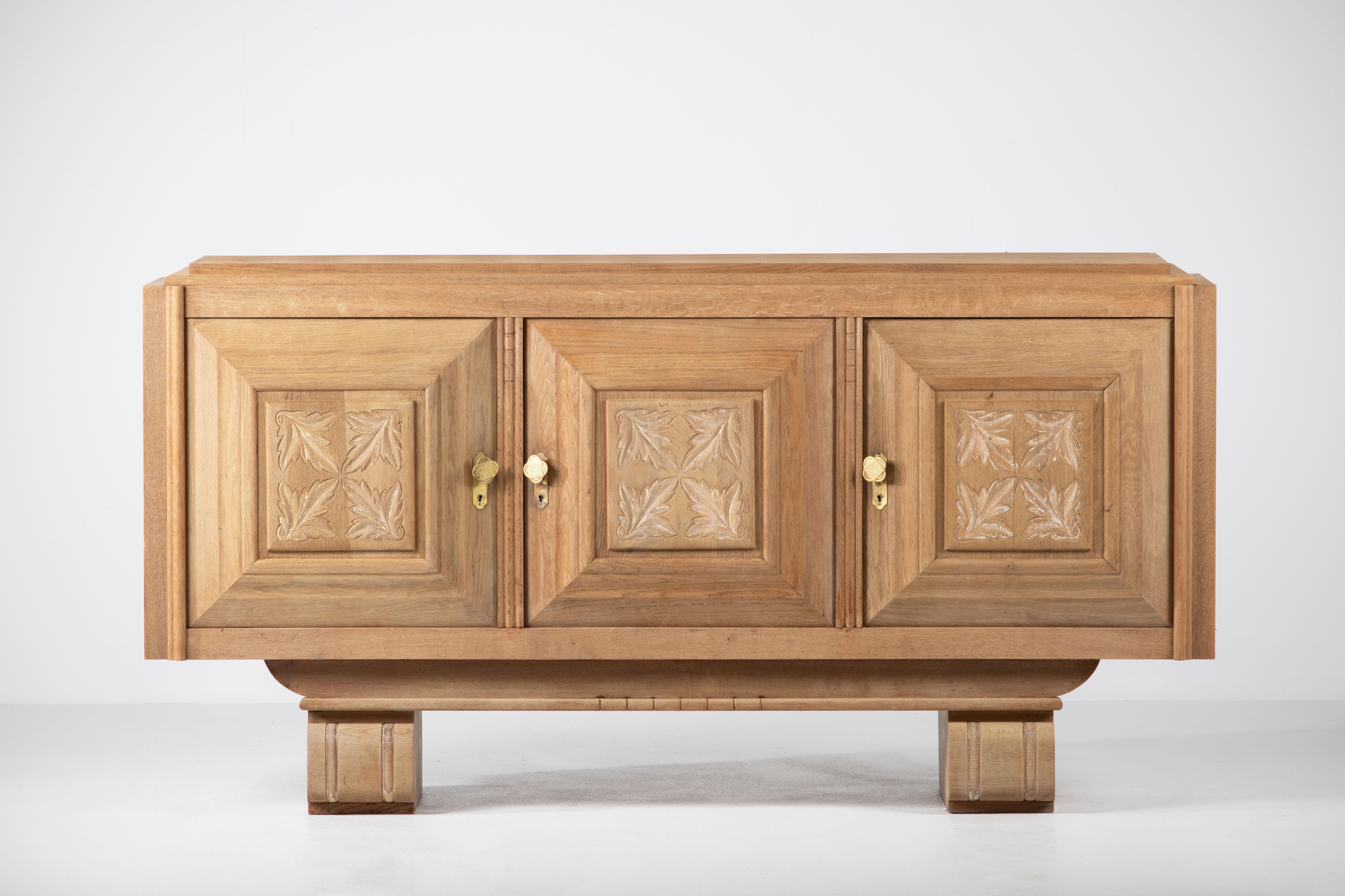 Very elegant Credenza in solid oak, France, 1940s.
Large Art Deco Brutalist sideboard. 
The credenza consists of three storage facilities and covered with very detailed designed doors. 
Very elegant 
The refined wooden structures on the doors