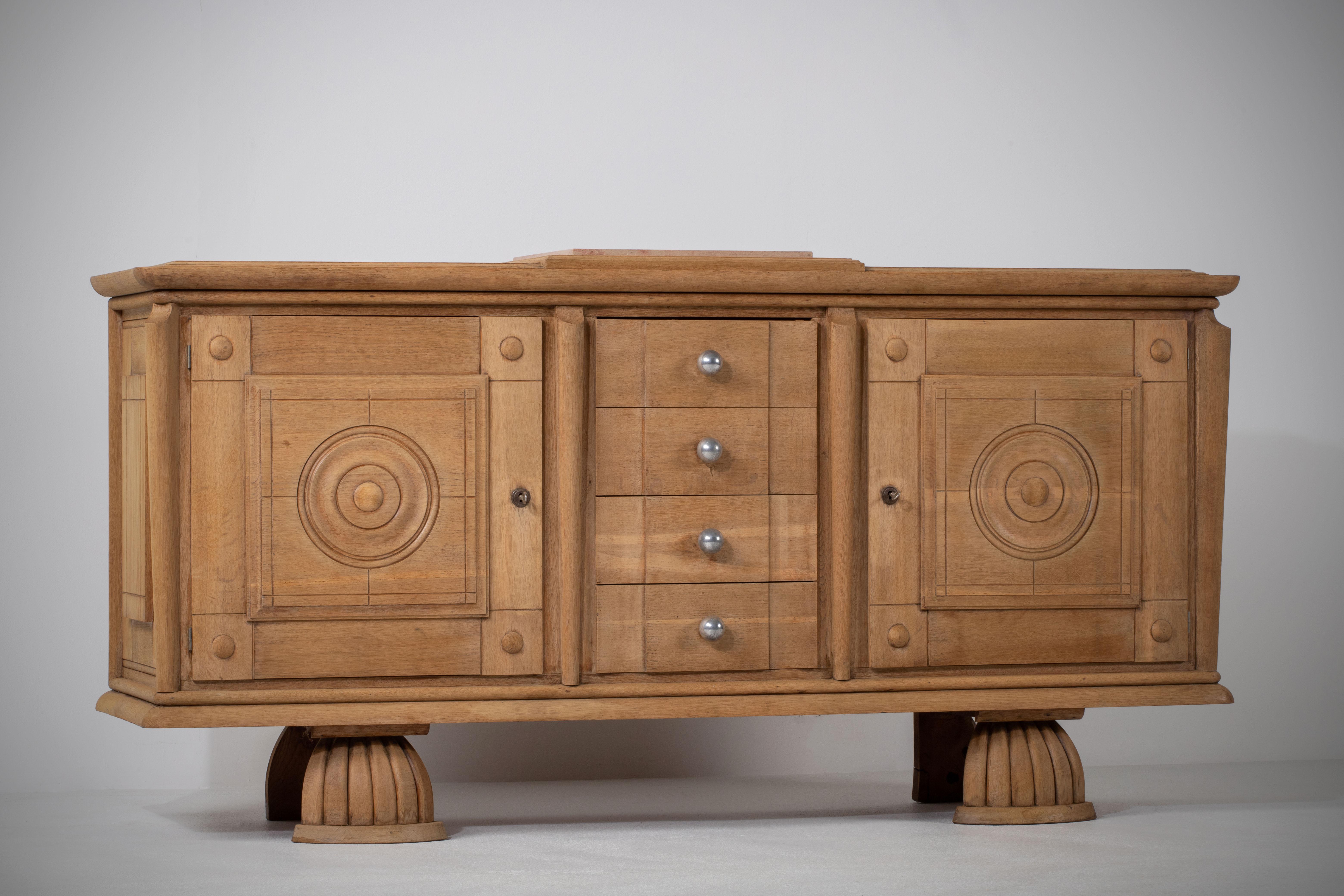 Credenza, solid oak, France, 1940s.
A matching sideboard is available.
Large Art Deco brutalist sideboard. 
The credenza consists of two storage facilities with the center drawers. 
The refined wooden structures on the doors create a striking