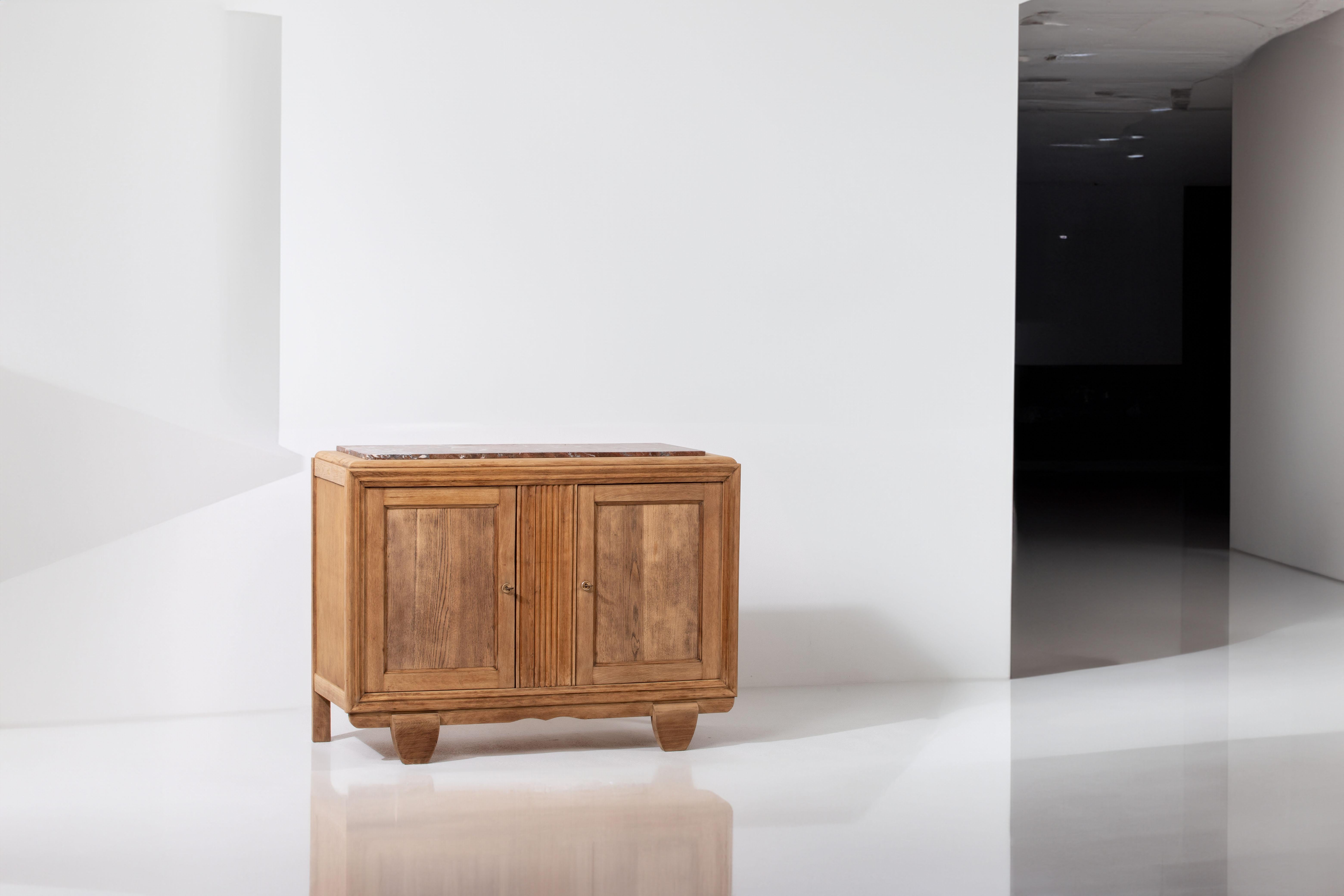 Immerse yourself in the timeless elegance of this compact oak credenza from the  40s. Crafted with meticulous attention to detail in 1940s France, this credenza captures the essence of Art Deco sophistication, reflecting an era characterized by