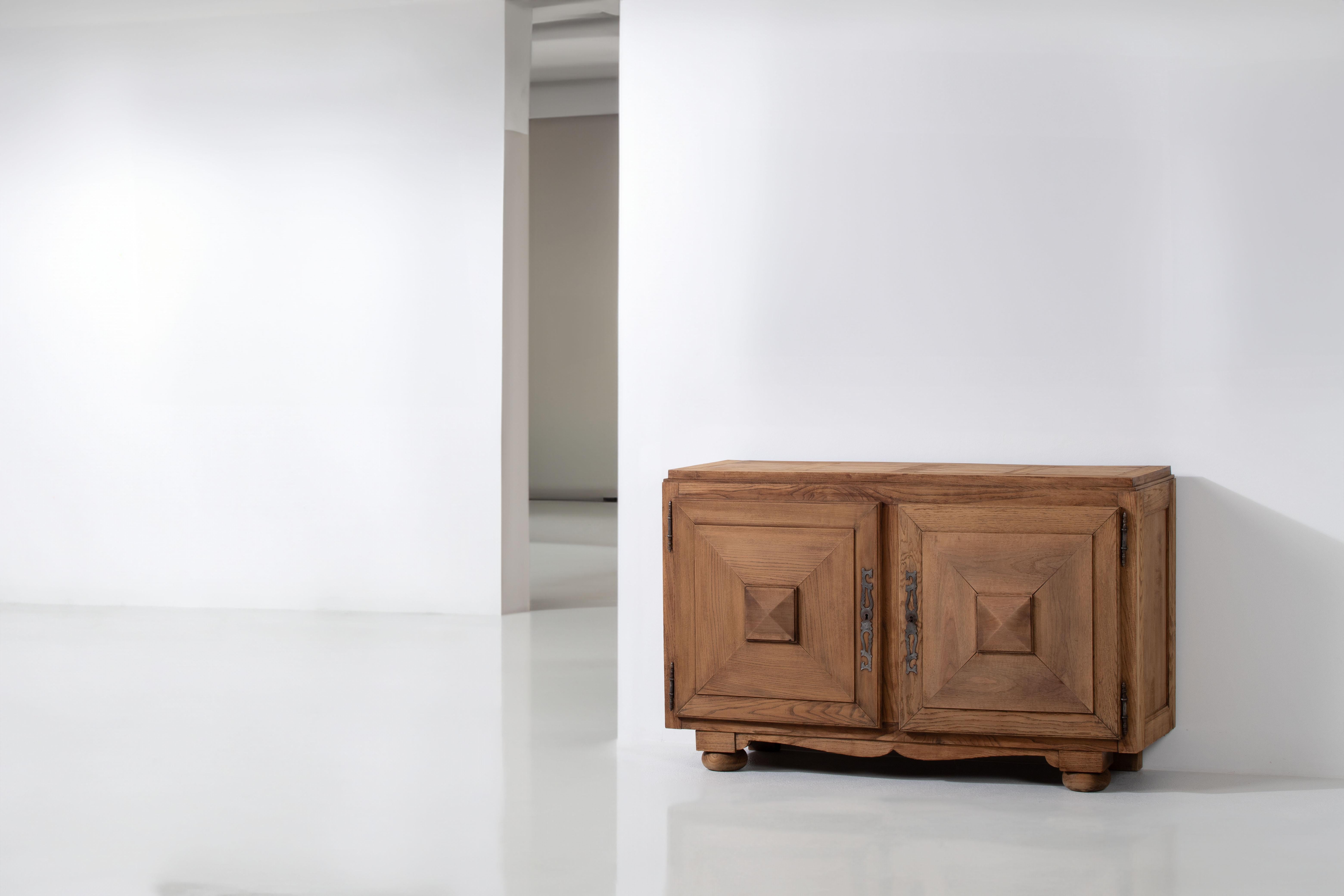Step into the timeless elegance of 1930s France with this exquisite oak cabinet. Crafted with care from solid oak, this piece showcases the refined design sensibilities of the era.

The cabinet features two doors adorned with graphic designs, a
