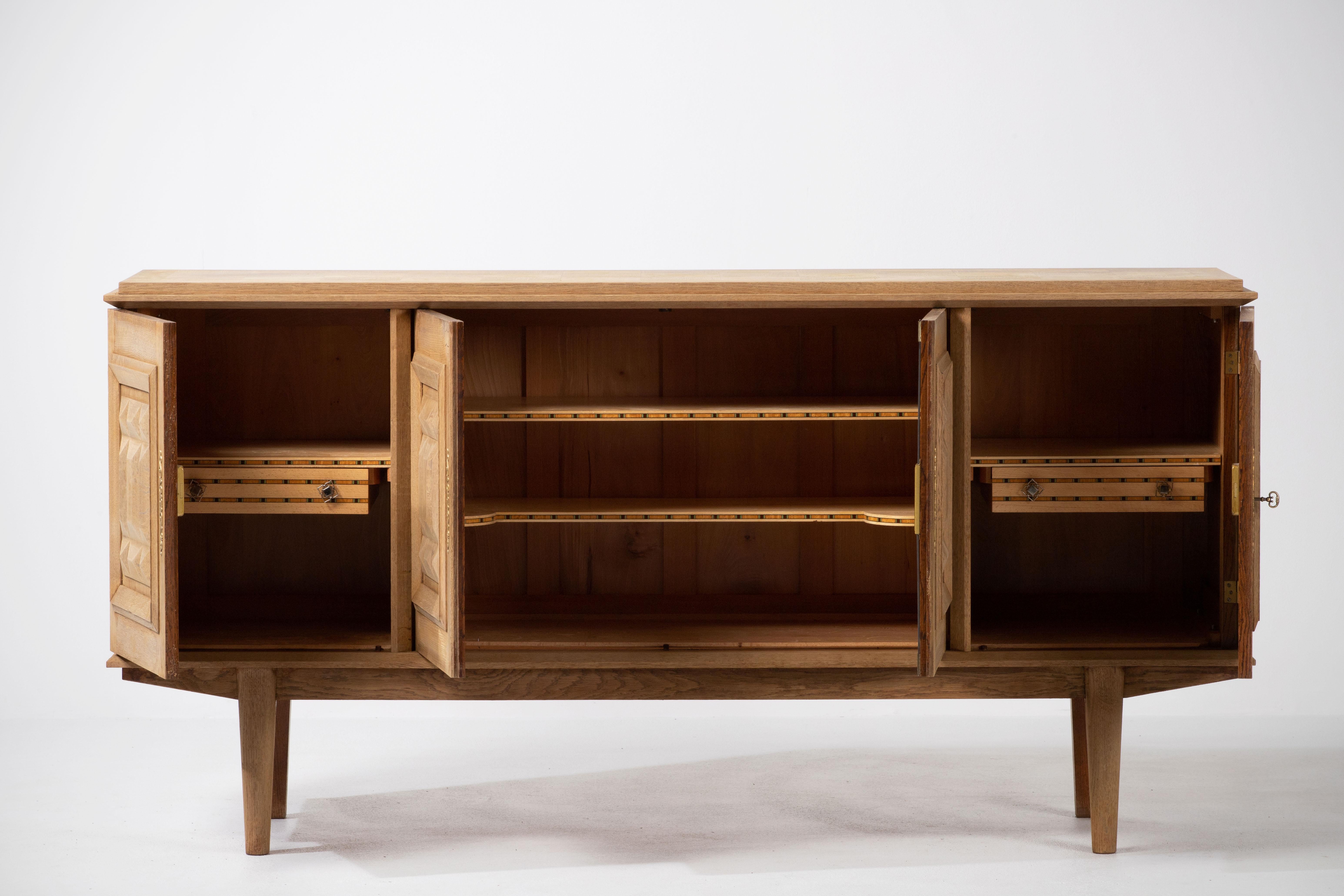 Credenza, solid oak, France, 1940s
Art Deco Brutalist sideboard. 
The credenza consists of four storage facilities and covered with very detailed designed doors. 
 