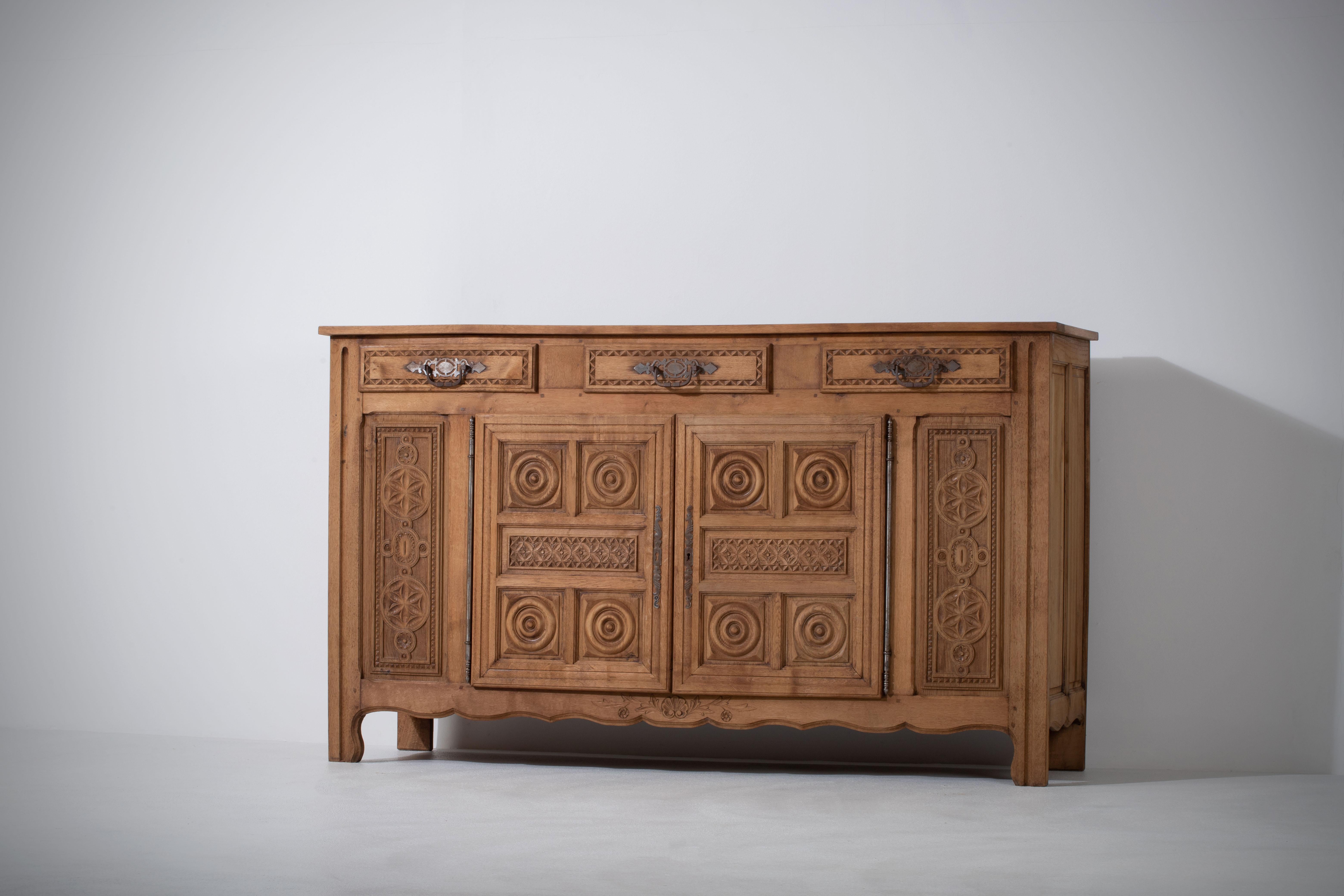 Credenza, solid oak, France, 1940s
Art Deco Brutalist sideboard. 
The credenza consists of storage facilities and covered with very detailed designed doors.