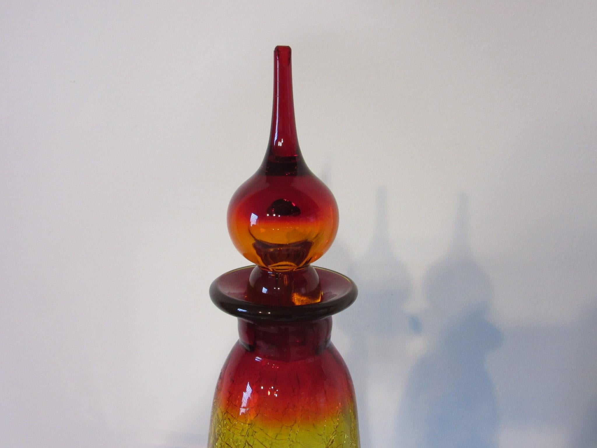 A nice sized amber and red crackle vase with matching raindrop stopper, the crackling affect gives this piece a fragile shocking appearance handcrafted by Joel Meyer for the Blenko glass company.
             