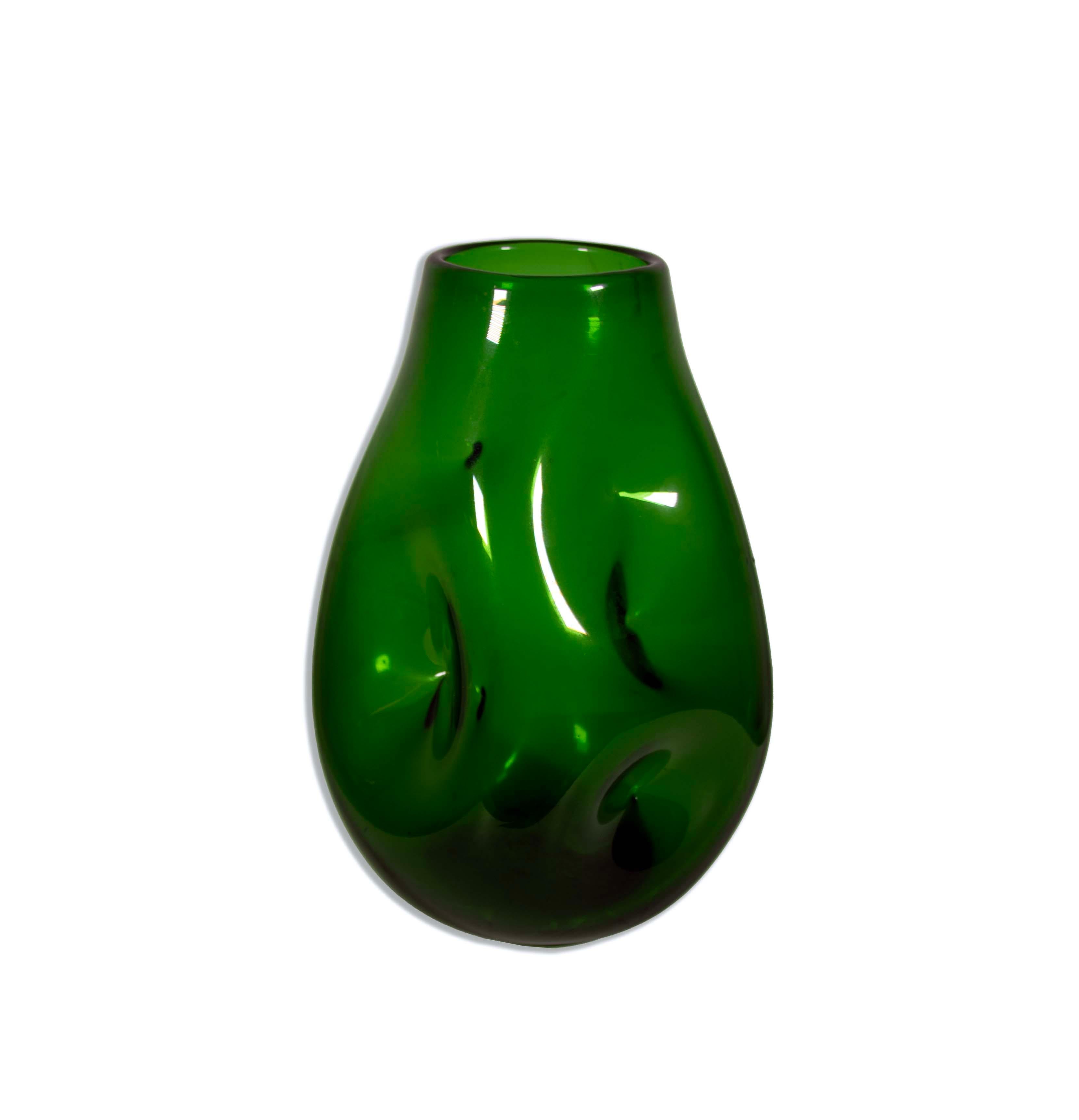 The Blenko Emerald Green Pinched Glass Vase, Model 921L, is a remarkable piece of mid-century modern glass artistry. Crafted by the renowned Blenko Glass Company, this vase features a captivating, pinched form in a beautiful emerald green hue.