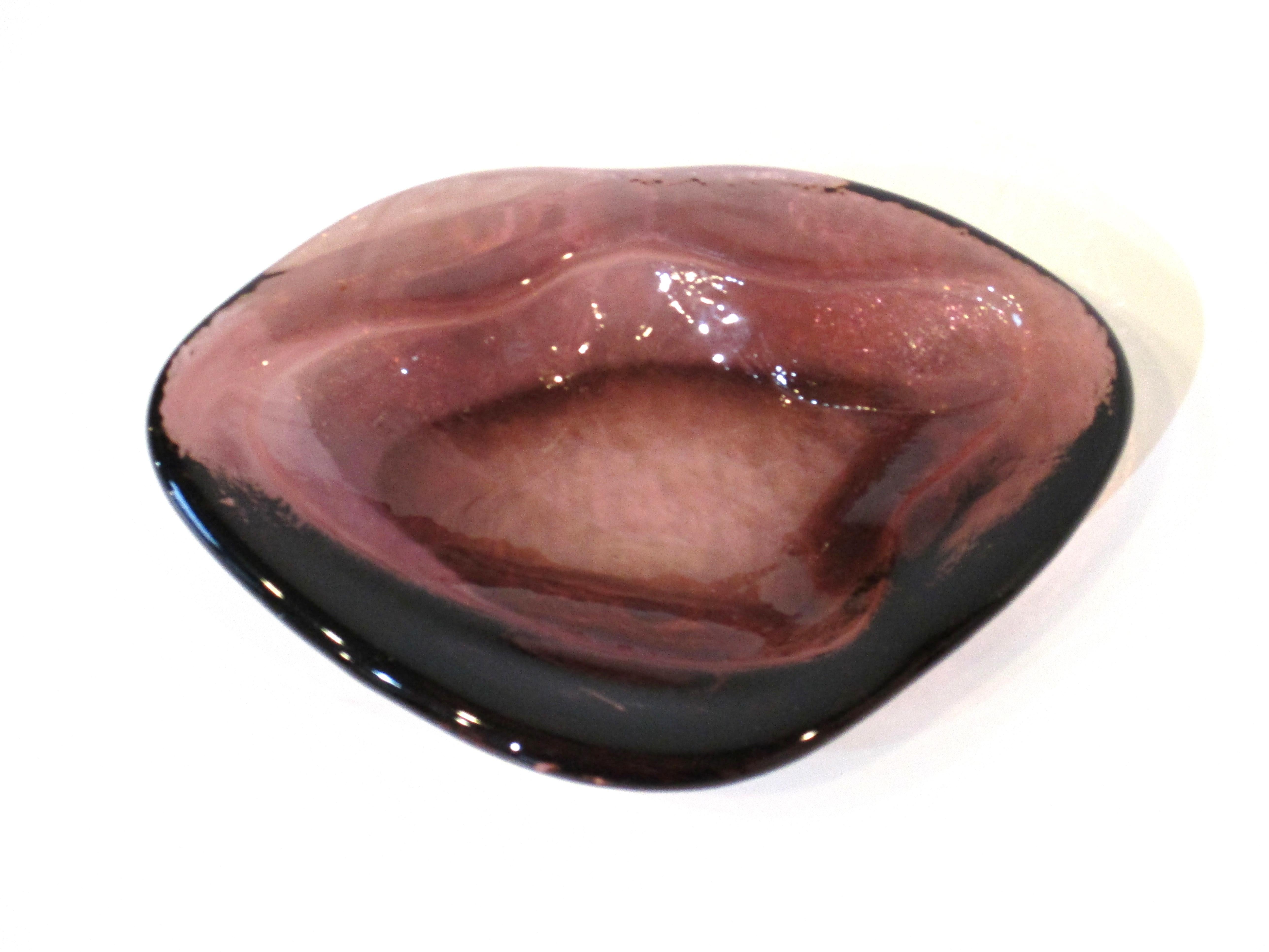 A freeform art glass bowl in a darker amethyst crafted by Anderson for the Blenko glass company in the 1950's .