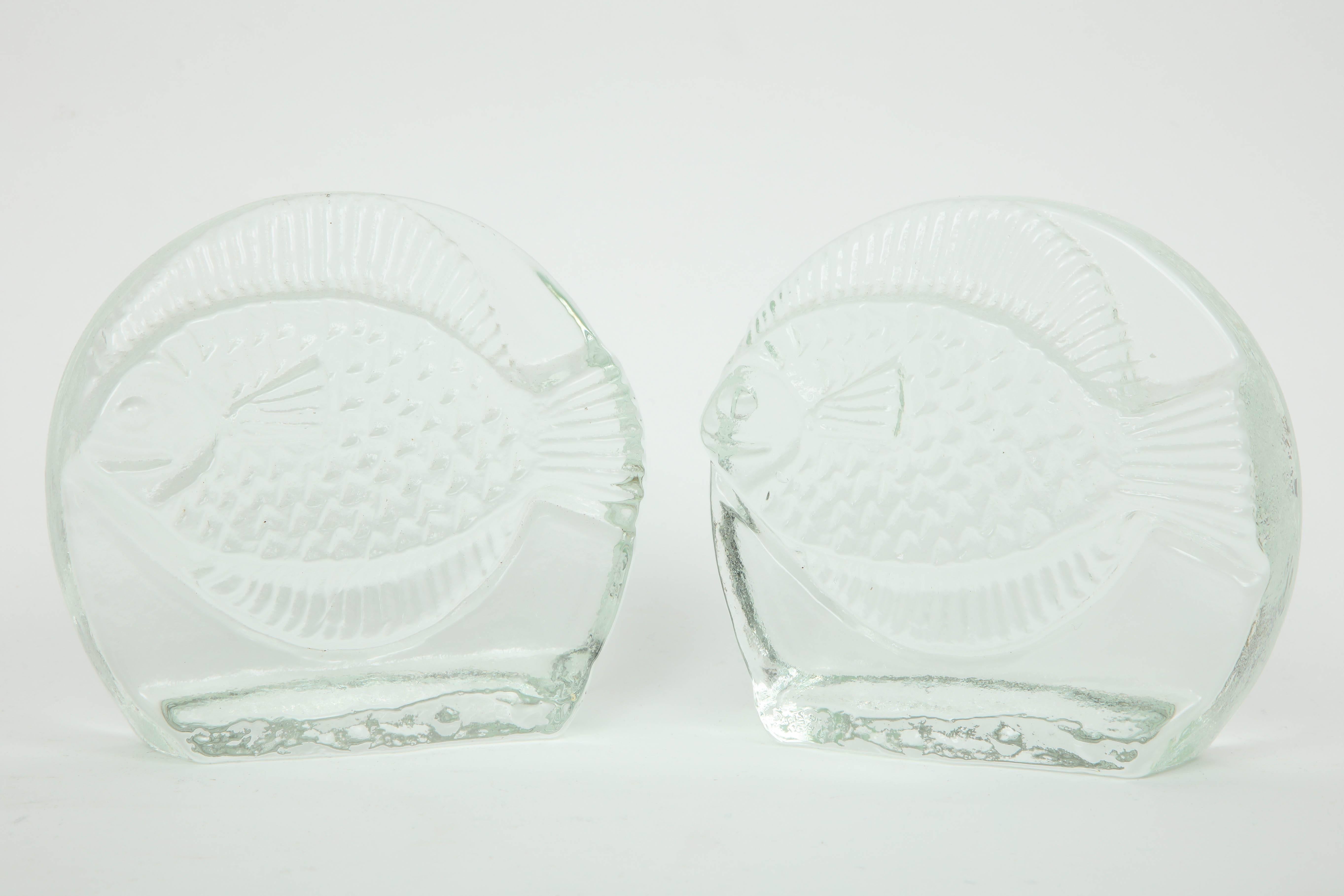 Midcentury solid cast glass bookends depicting a fish in bas relief technique.