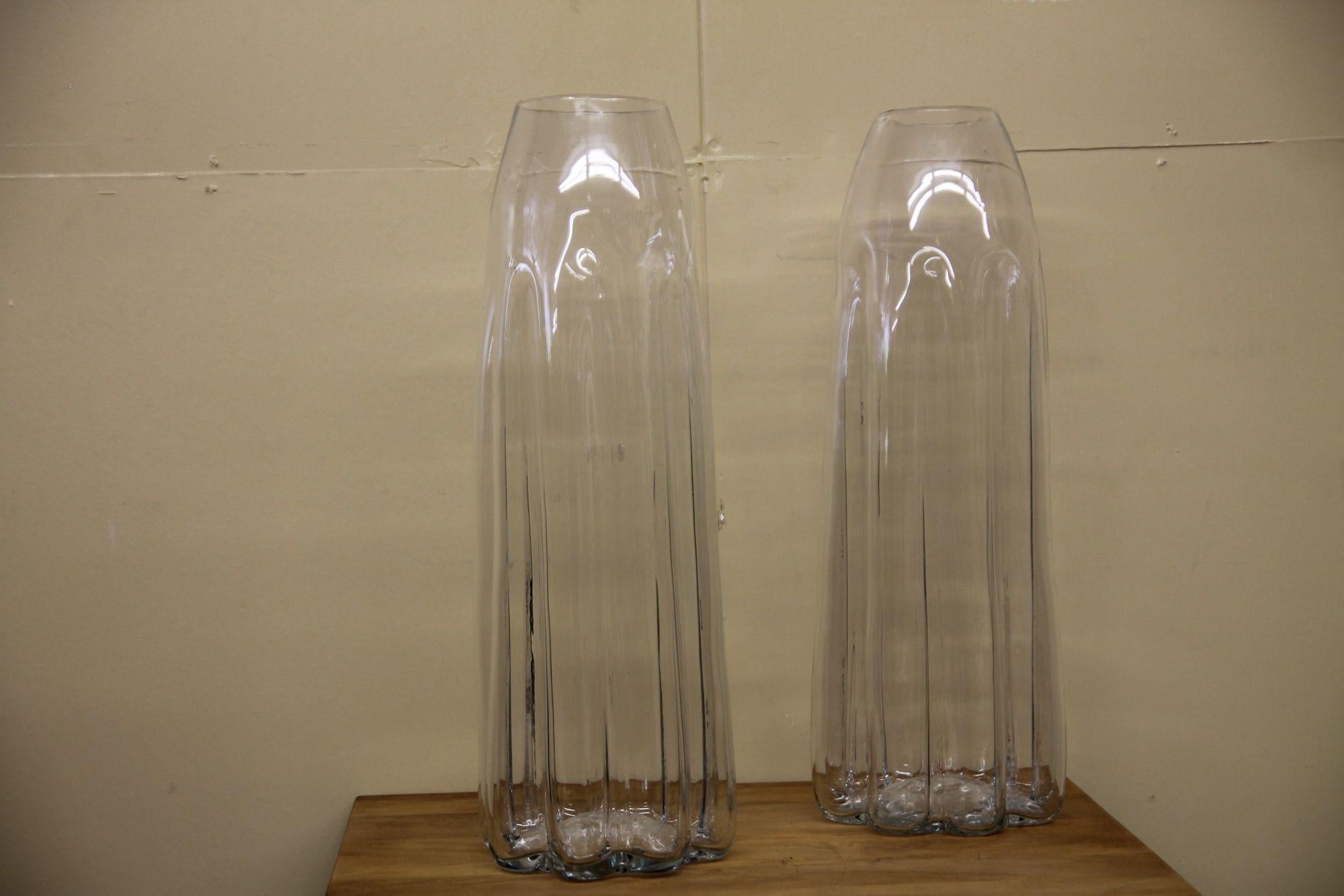 Pleased too offer this great pair of hand blown large vases. The top opening are slightly different but that is to be expected with a hand made piece. These oversized vases will look great on a table as well as the floor.