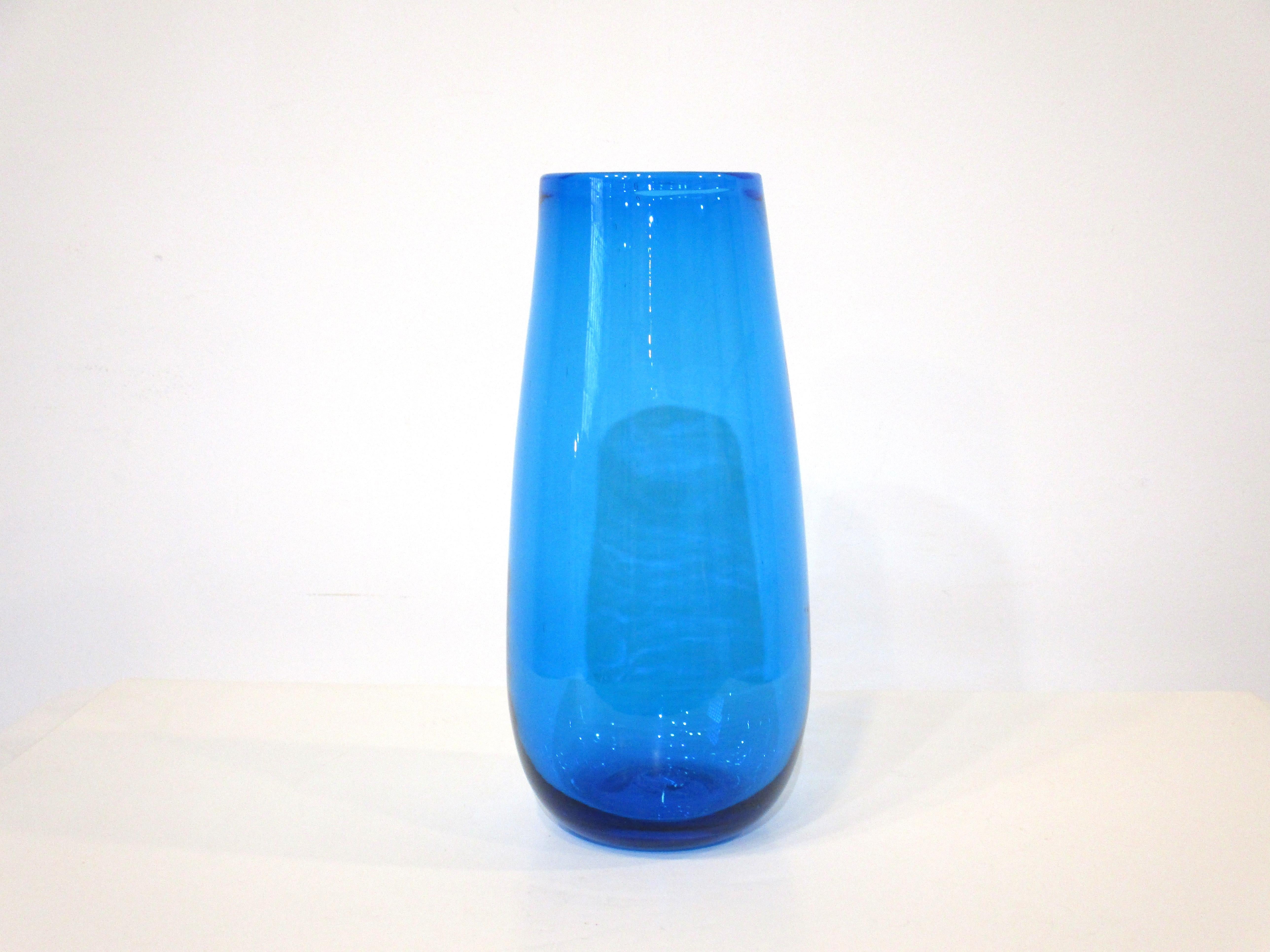 A handblown blue glass vase by artist Wayne Husted for the Blenko Glass company one of the top glass companies during the Mid Century era. Colorful ocean blue tone perfect for flowers and other arrangements.
