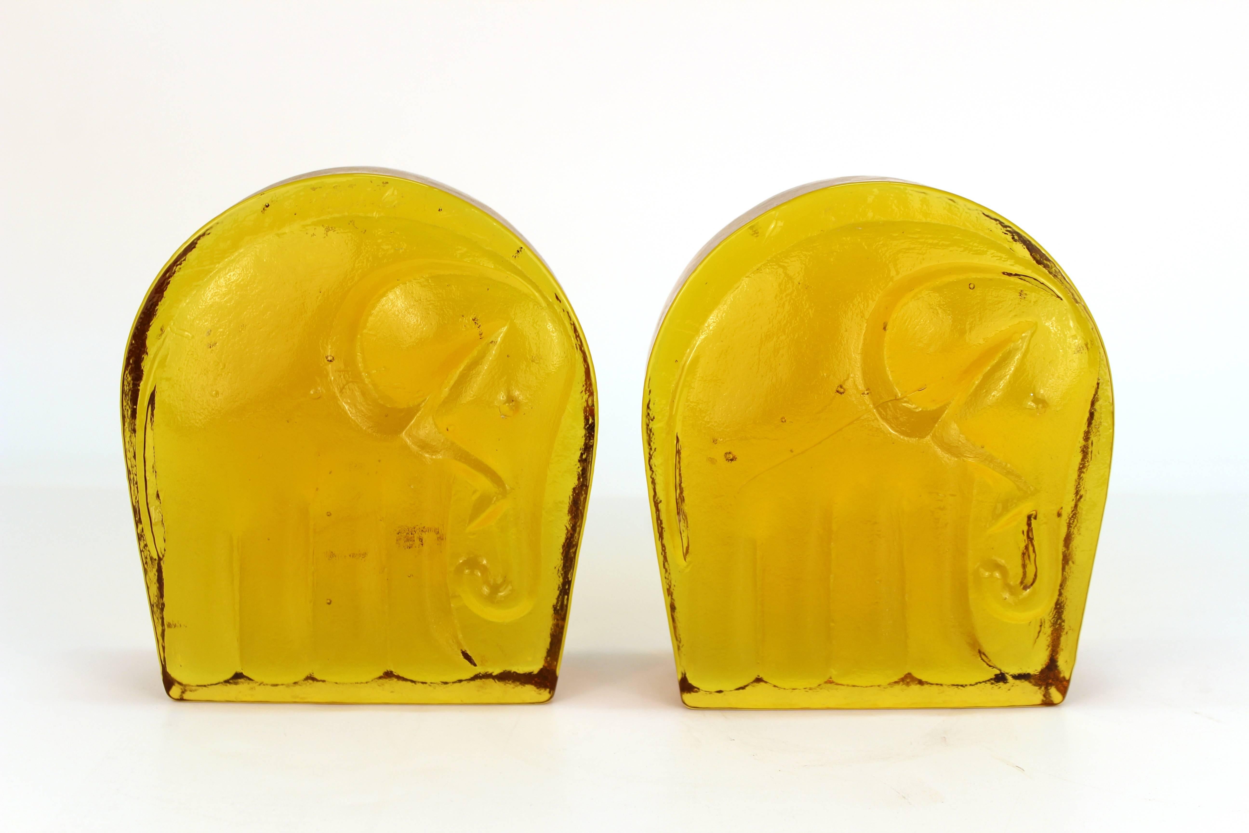 A pair of Mid-Century Modern glass bookends depicting elephants on the front end. The pair was made in the United States by Blenko in the 1960s and is in very good vintage condition.