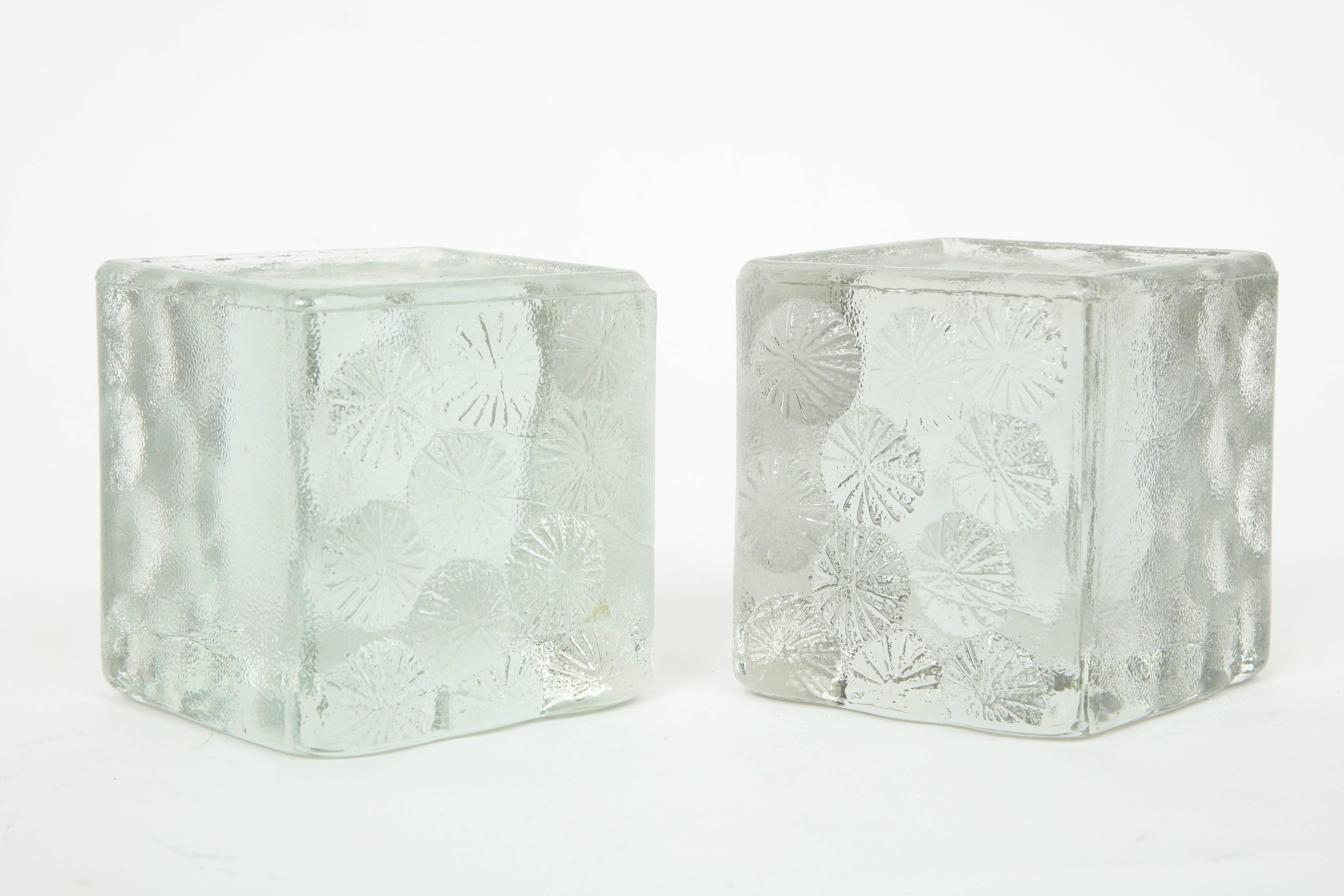Pair of midcentury solid glass block bookends with rows of raised stylized flowers. Great in a bookcase or a coffee table as sculptural elements.