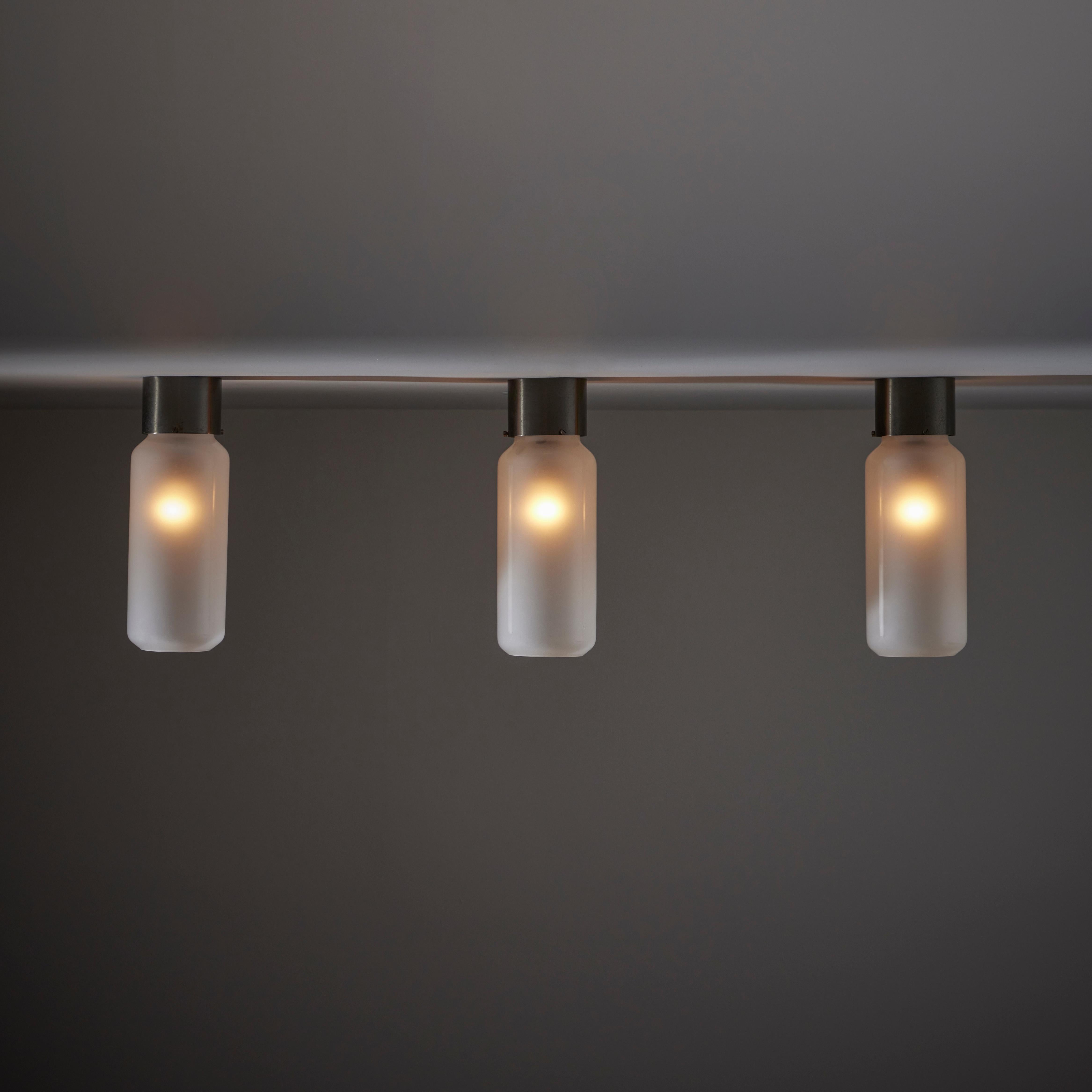 'Bidone' flush mounts by Caccia Dominioni for Azucena. Designed and manufactured in Italy, in 1958. Industrial flush mounts with blackened polished steel canopy and frosted glass cylindrical shade. Each sconce holds one E27 bulb, adapted for the US.