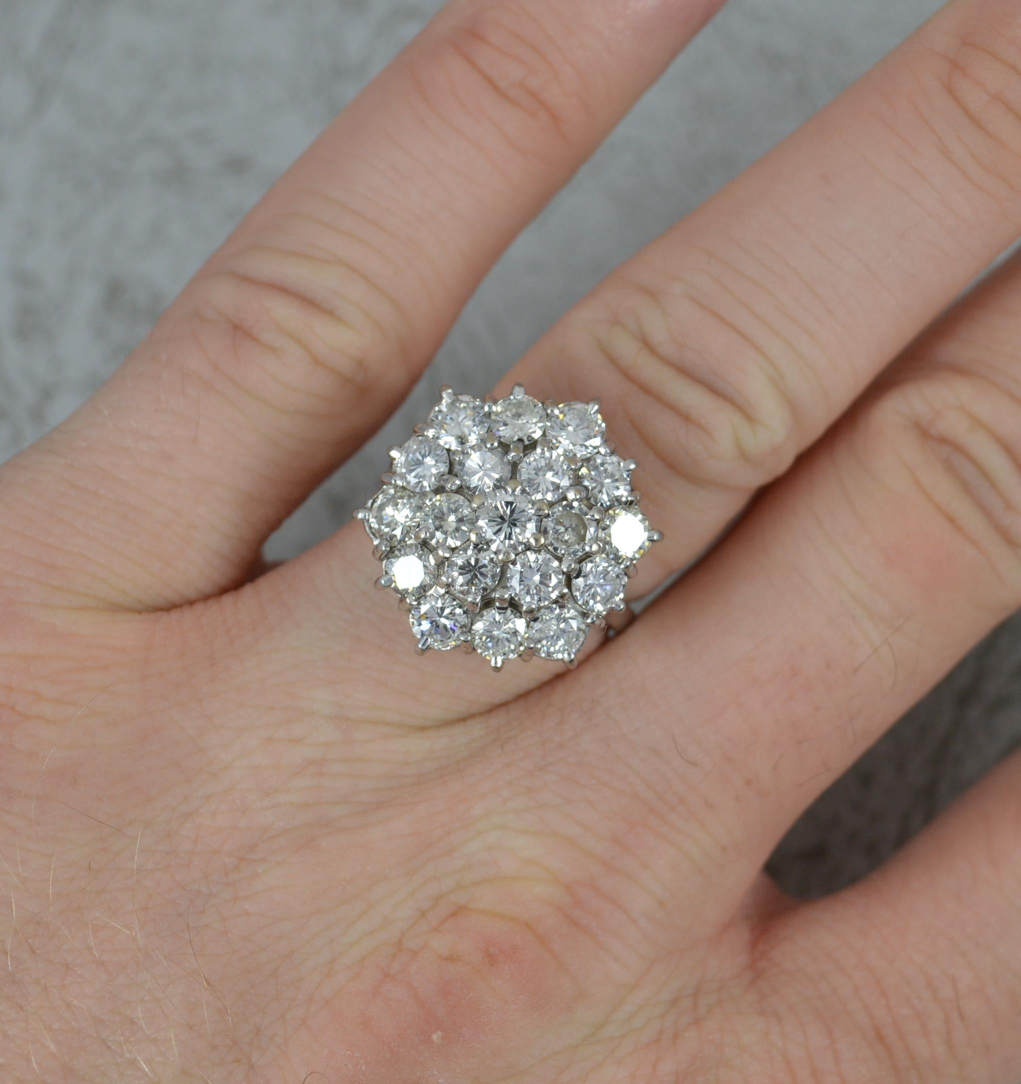 A large natural diamond cluster cocktail ring.
Solid 18 carat white gold example.
Set with nineteen natural round brilliant cut diamonds forming a hexagonal shaped cluster. Approx 3.25 carats total. Clean, bright and sparkly.
17mm x 20mm cluster.