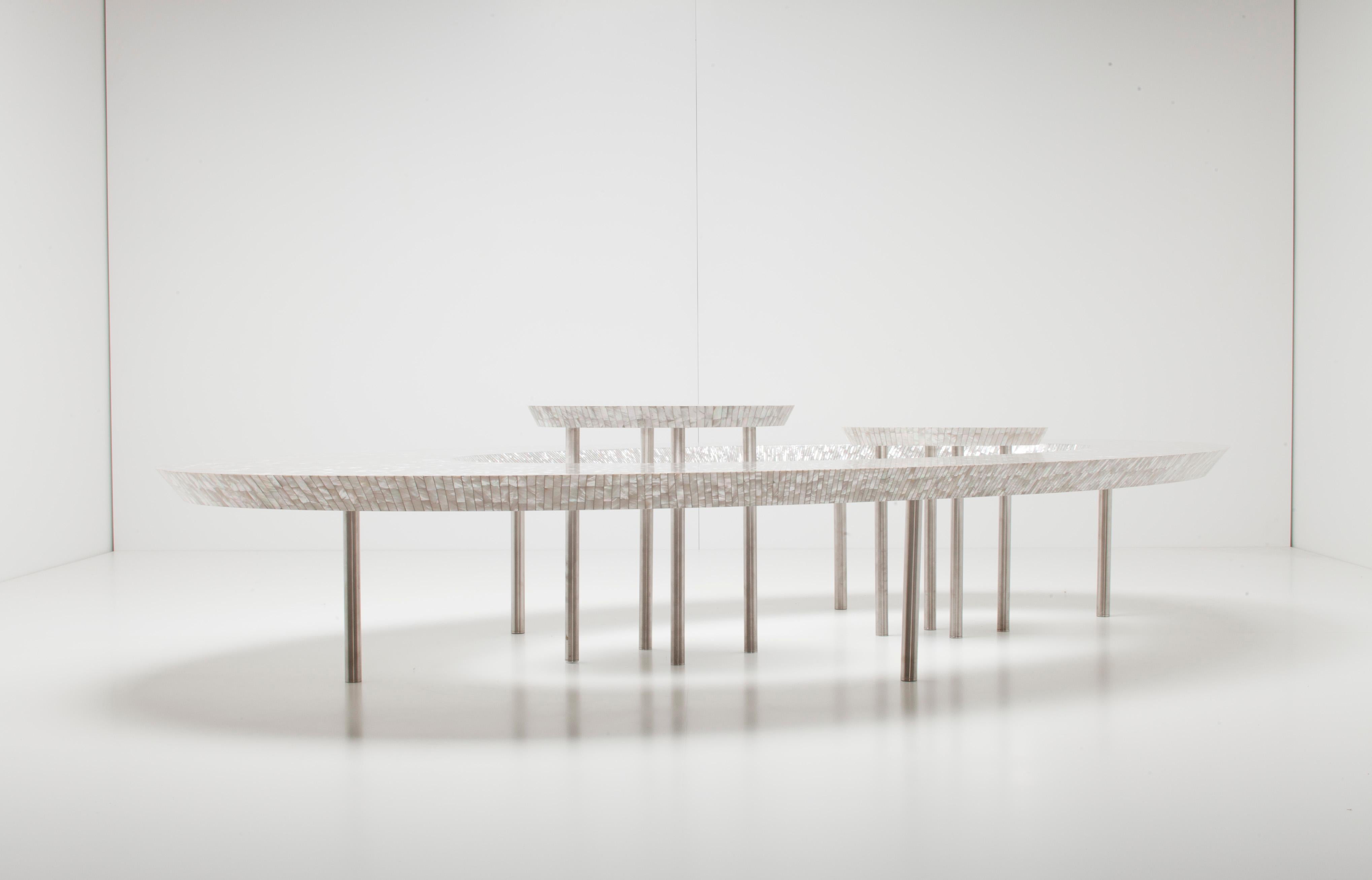 Supported by metal legs, the iconic ellipse of the coffee bean table is made entirely of mother of pearl. The “beans” which nest within the centre can be liberated to suit individual places and layouts.
 