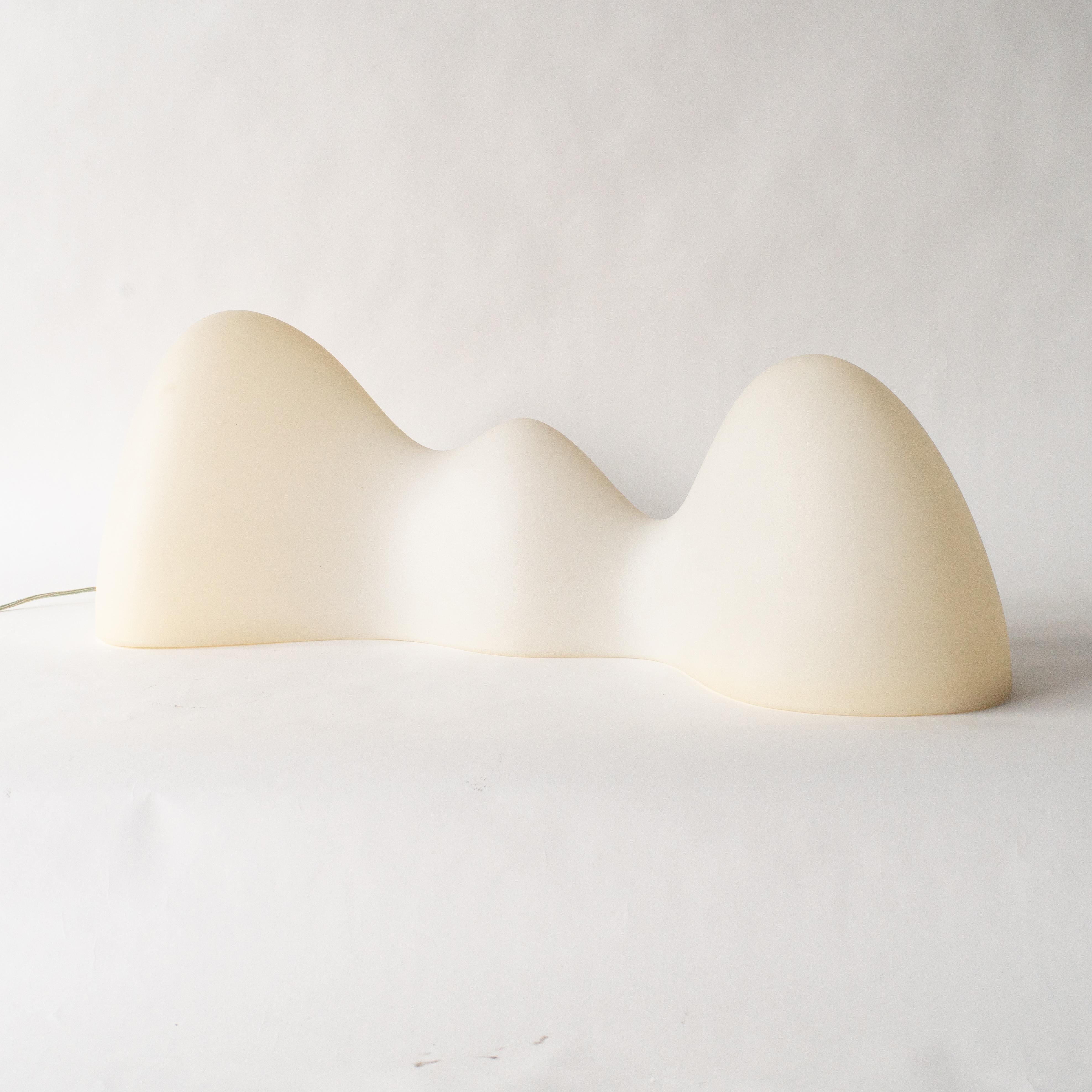 Lámpara de pie diseñada por Karim Rashid. Fabricado por Foscarini a principios de la década de 2000.
De polipropileno blanco con jarrón de acero. También hay disponible un modelo amarillo pequeño de sobremesa o de pared.  Esta iluminación es un