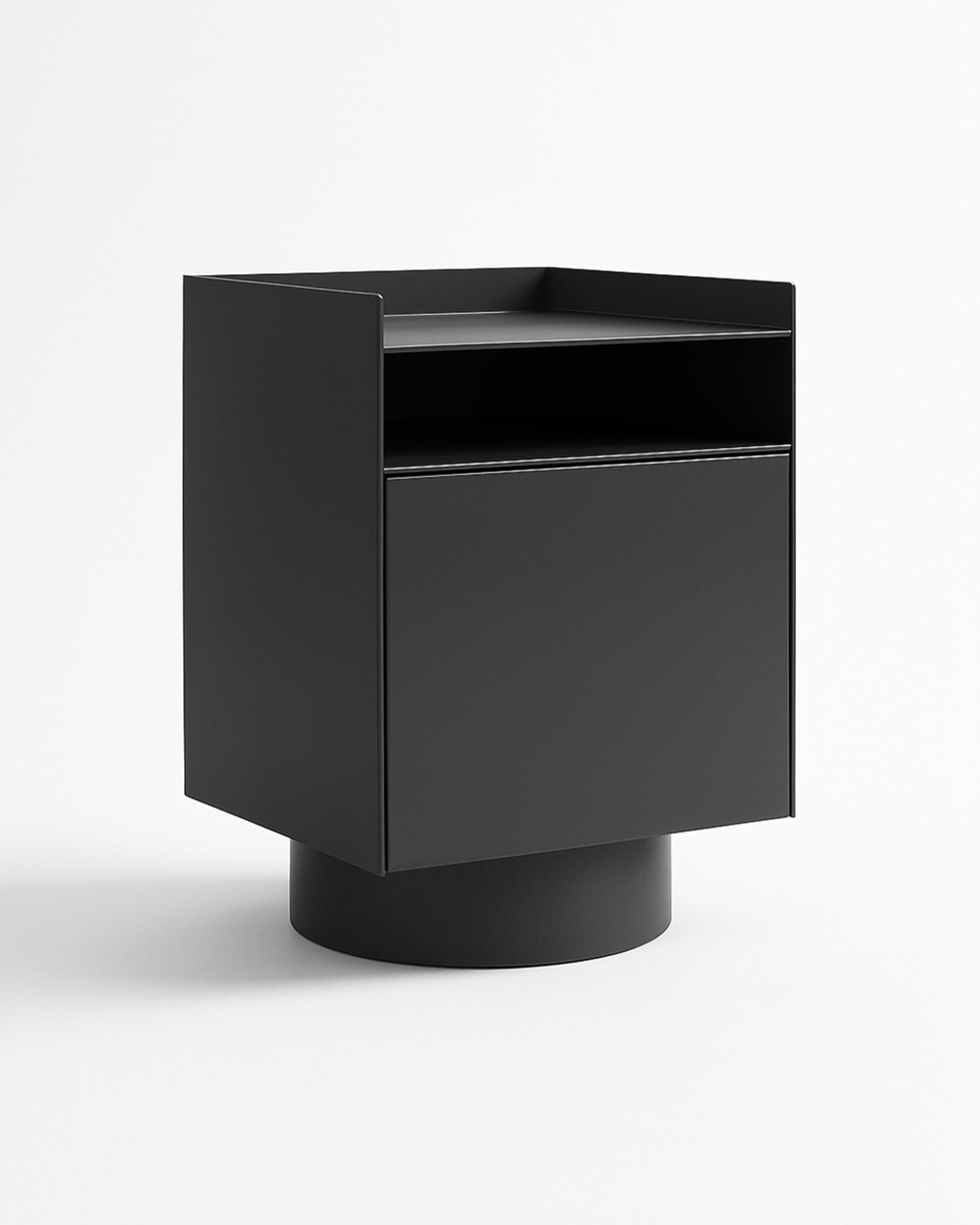 Bloc è un comodino moderno definito da linee decise e semplicità architettonica. Elevata su una base cilindrica, la sua forma sembra al tempo stesso solida e visivamente equilibrata.

Un ripiano superiore aperto permette di tenere a portata di mano