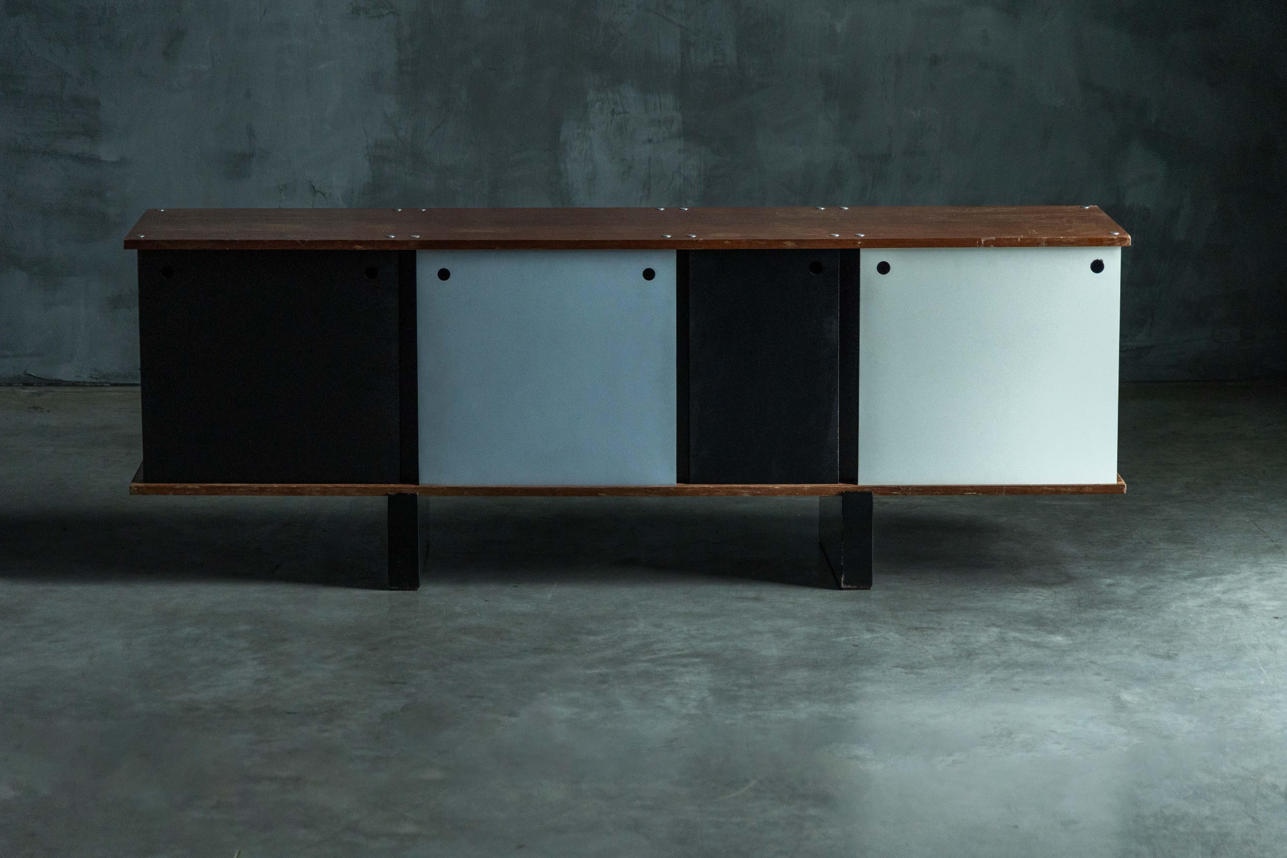 Sideboard 'Bloc' by Charlotte Perriand, a timeless piece designed for Cité Cansado. Composed of sturdy shelves veneered in a range of different woods, reinforced by sleek black lacquered sheet metal backs and side panels, this sideboard guarantees