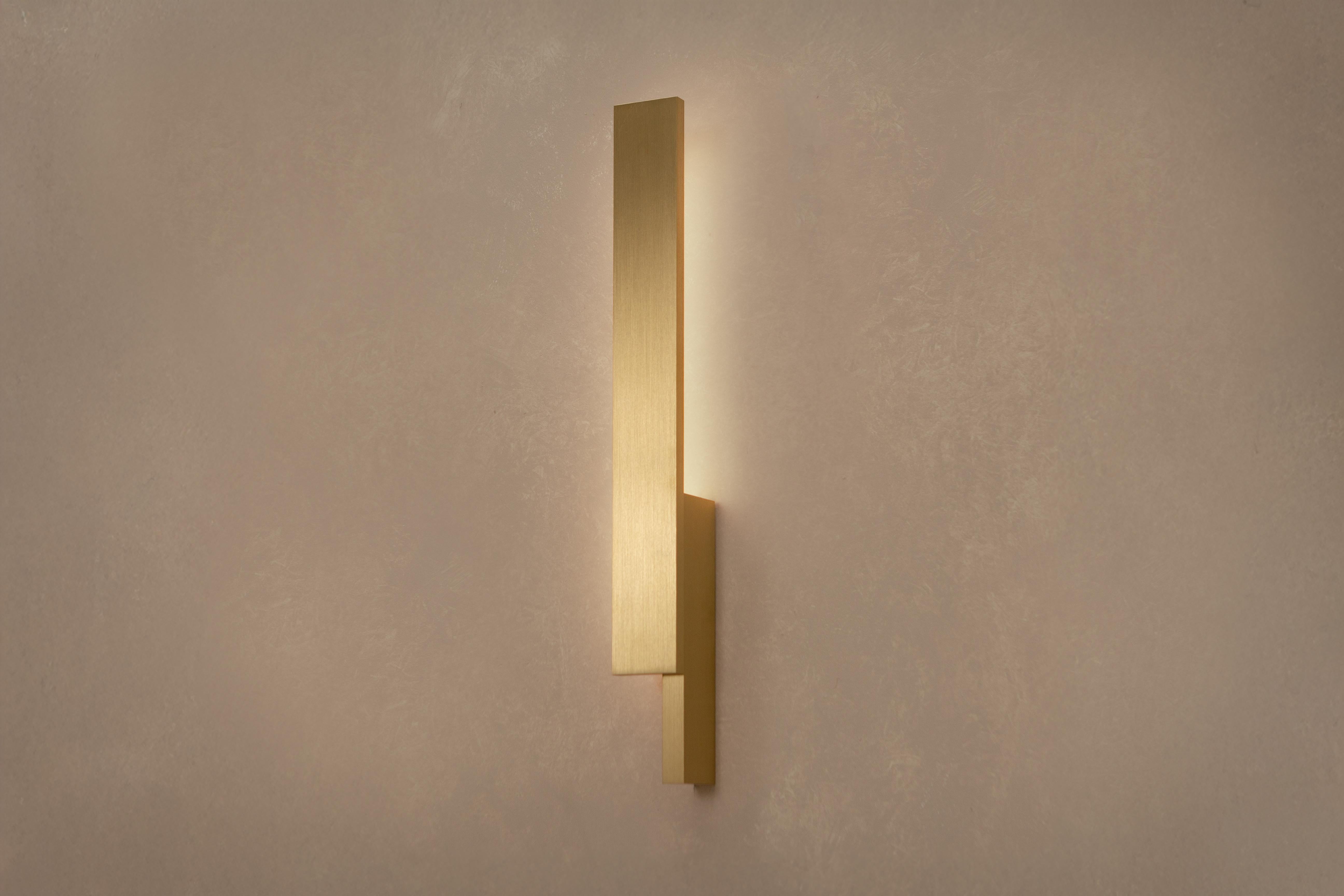 El aplique de pared Bloc se inspira en la escultura minimalista clásica de los años 60, reimaginada mediante una interacción de bloques sólidos que se entrecruzan. Su diseño asimétrico permite combinaciones a izquierda y derecha, por lo que se