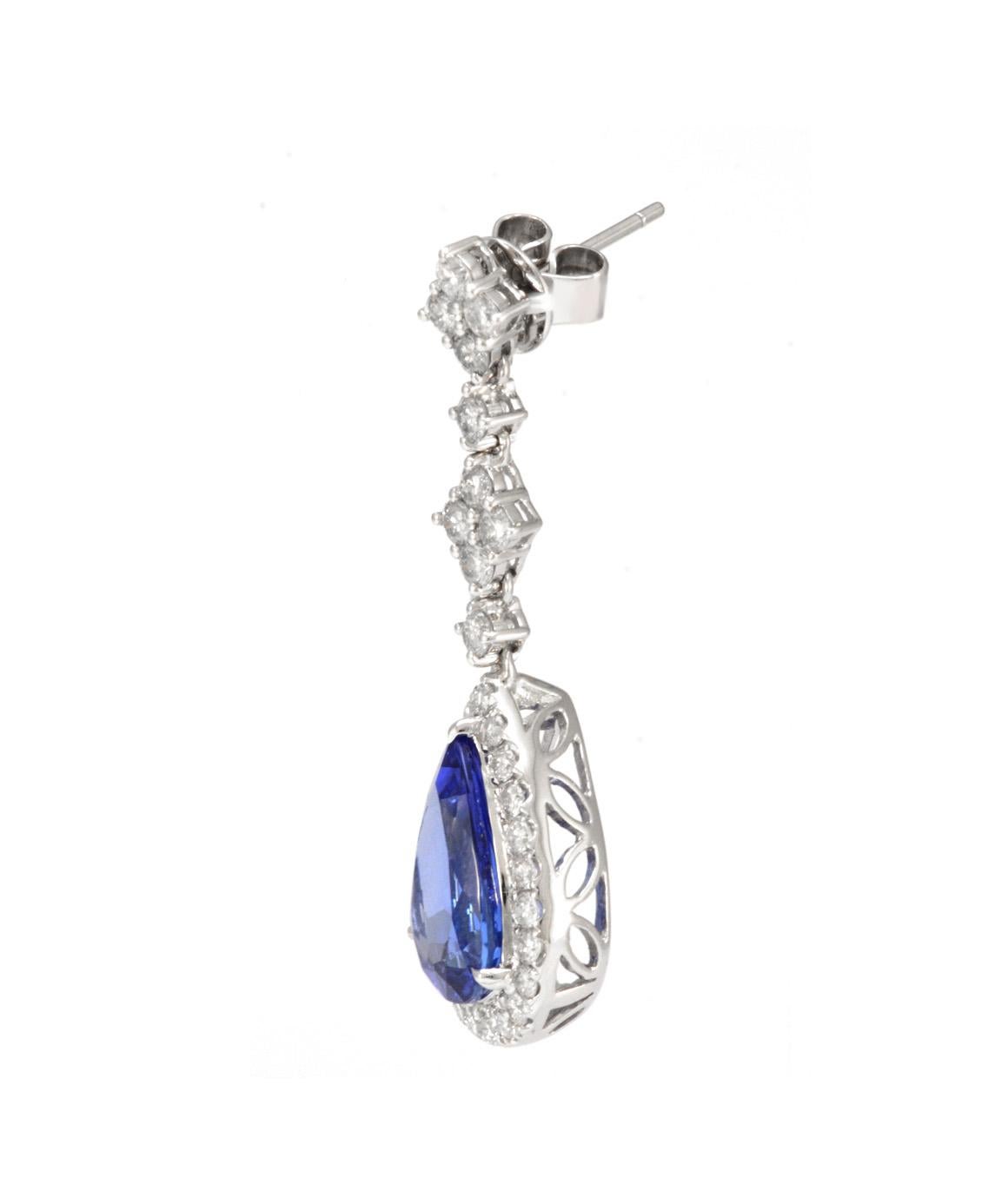 EXCELLENT CONDITION! These GORGEOUS Block D pear shaped Tanzanite drop earrings are truly spectacular. The tanzanite in each earring measures approximately 13.50mm X 8.98mm at its widest point. Each tanzanite is set in a pear shaped halo surrounded