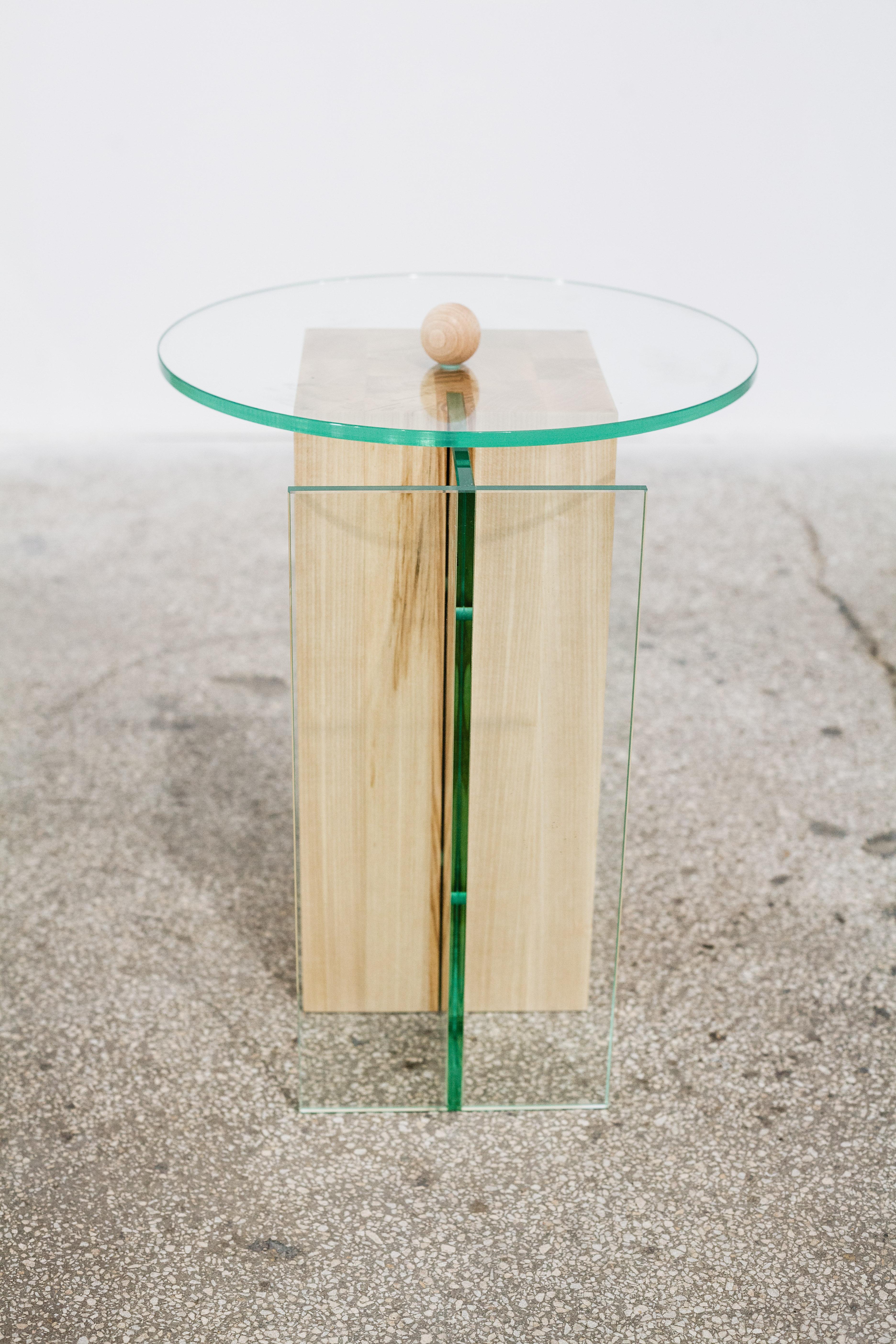A massive rectangular shaped ash wood volume, in composition with glass, that serves as a side table/object. The object is part of a series named Form before function, where the focus is moved on the aesthetic of each object, rather than on its