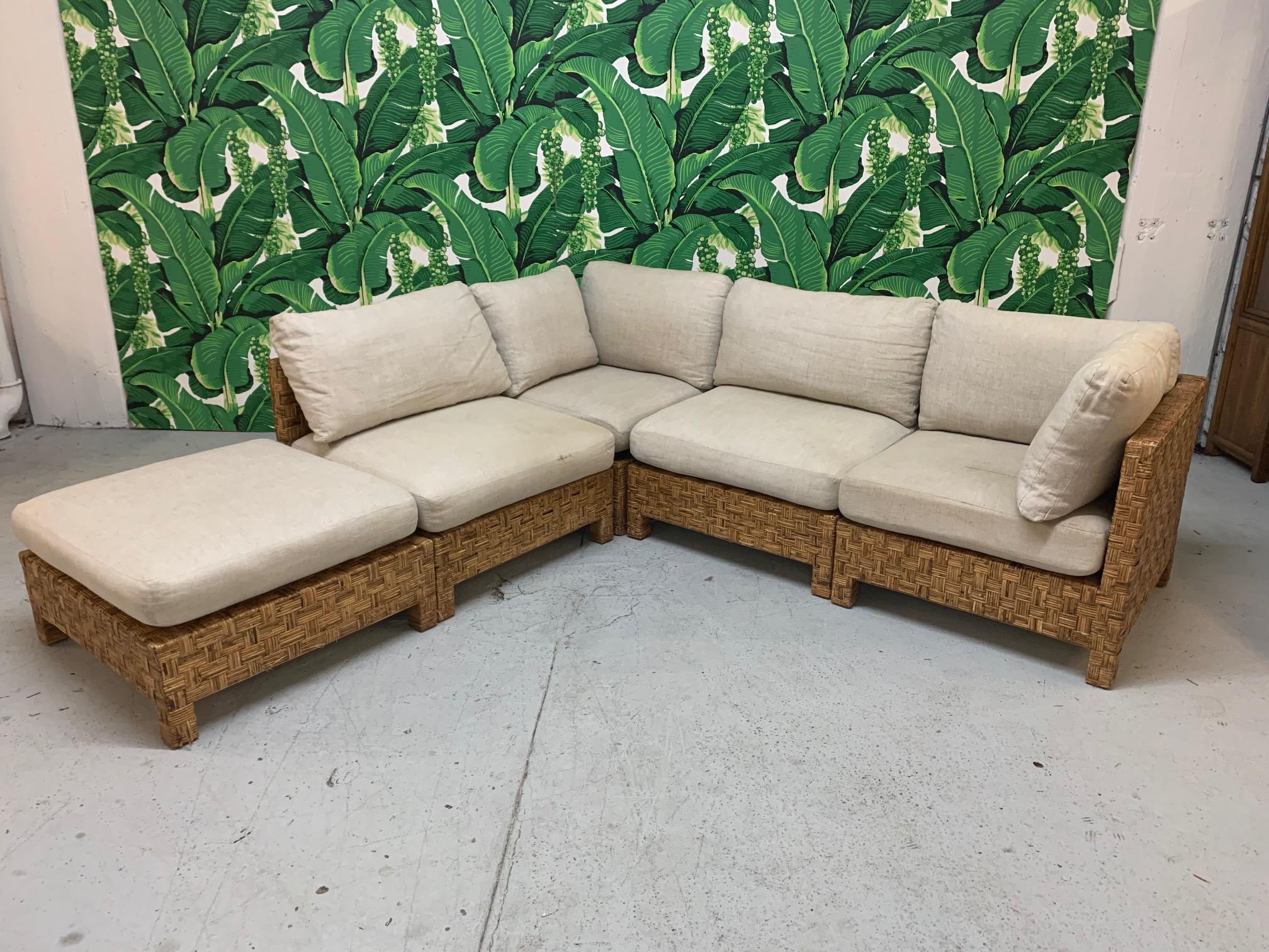 5-piece sectional sofa features woven block wicker design and modular pieces that can be arranged in several configurations. Design in the manner of John Hutton. Consists of 2 corner pieces, 2 side pieces, and an ottoman piece. Good vintage