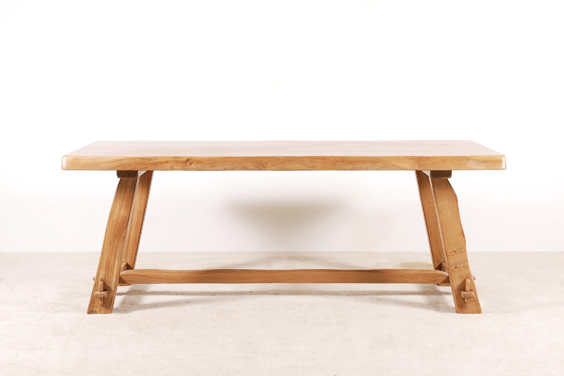 Nice elm dining table designed and manufactured by Aranjou. France, 1950.

This table is made of natural blond elm wood and sculpturally crafted by hand.
Very minimalistic, Brutalist shaped, this table is for 8 persons.
Nice work of mortise and