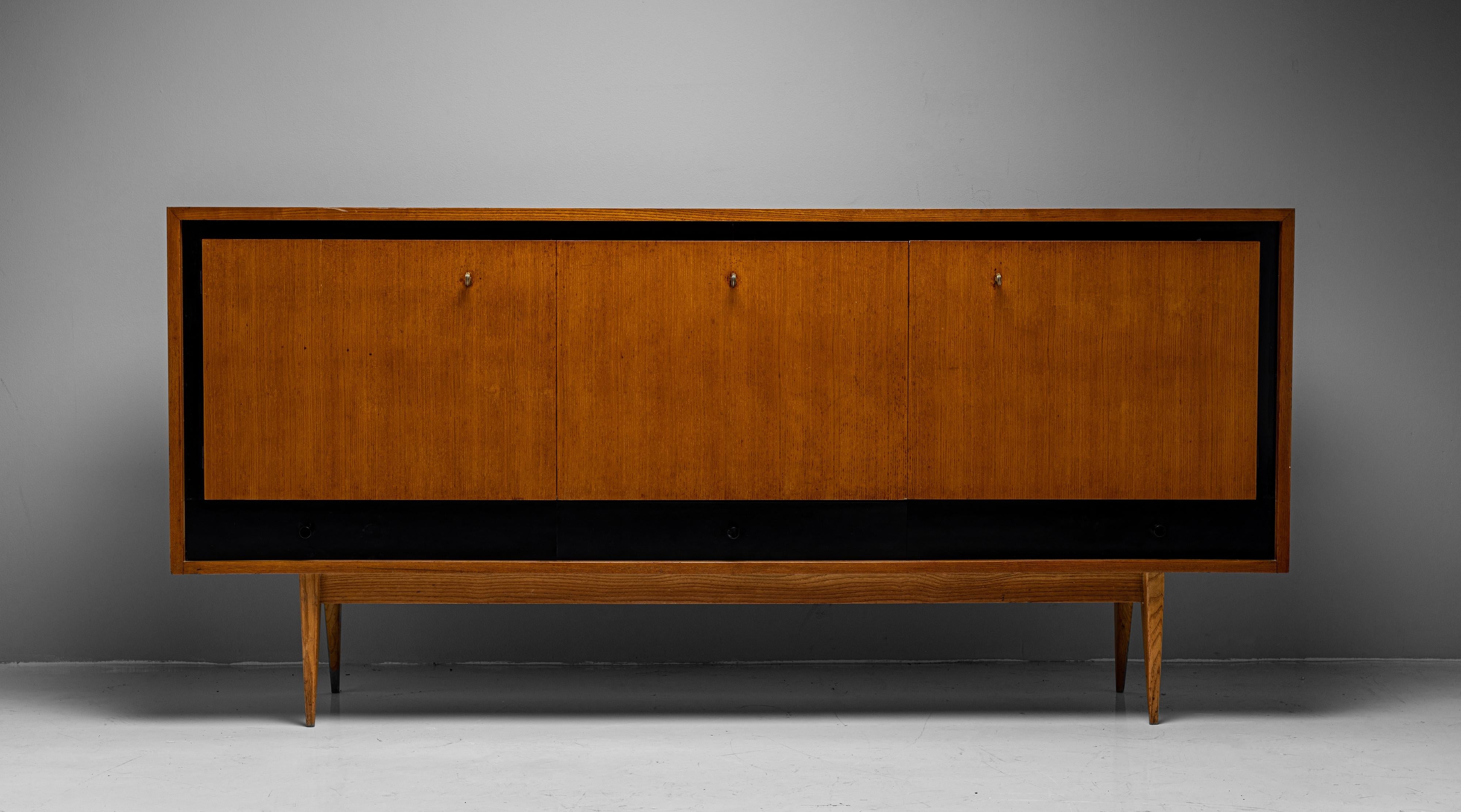 Blonde Ash Enfilade by Charles Ramos

France circa 1950

Constructed in blonde ash with ebonised detailing. The two side compartments open up while the center has a drop down door.

Measures: 78.5”W x 17.75”D x 36.75”H.

 