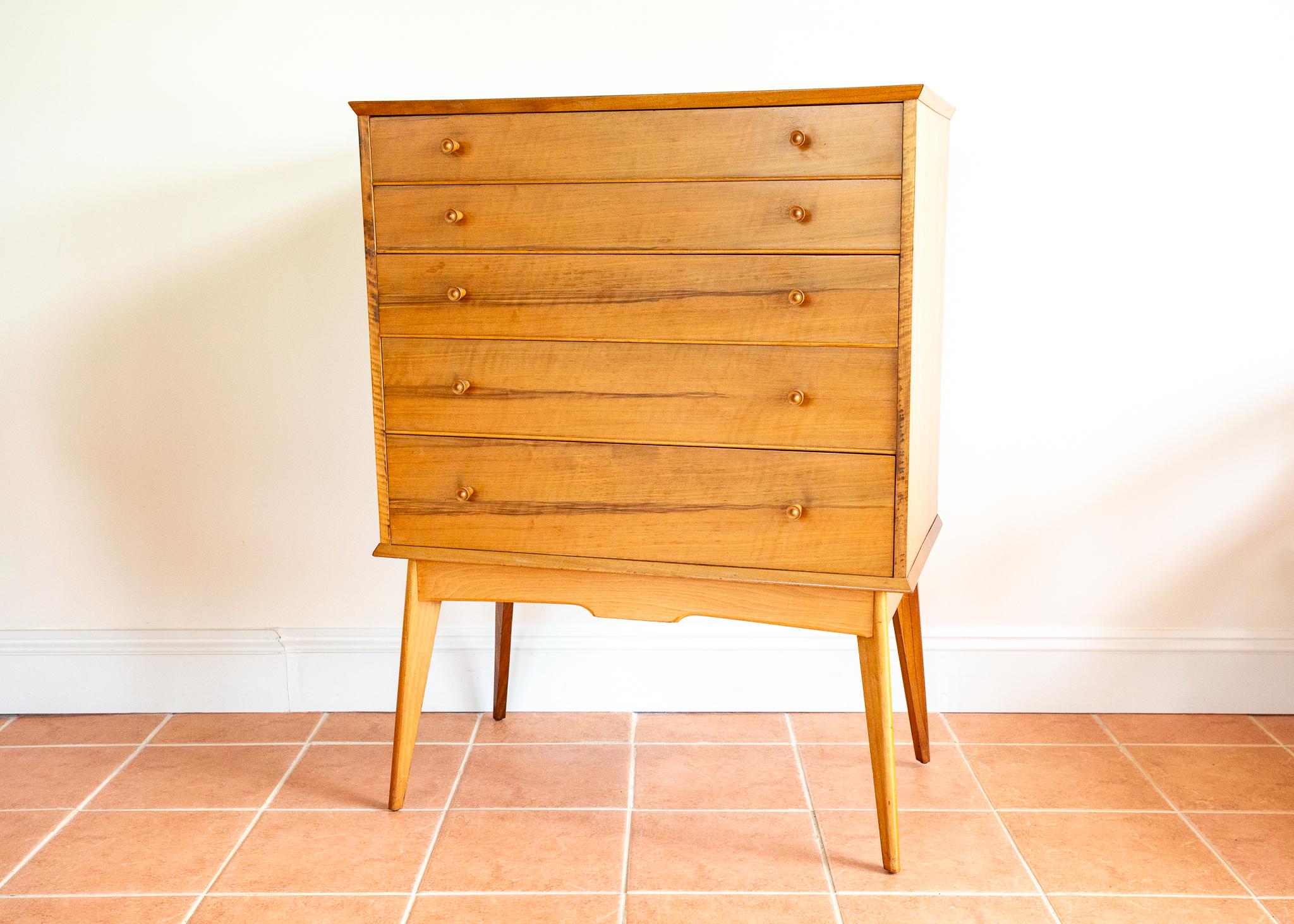 A very impressive, rare and strikingly attractive Mid Century blonde walnut chest of drawers in lovely vintage condition. Retailed by Heal’s, designed by Alfred Cox and made by his much-heralded eponymous British company, most likely in the early