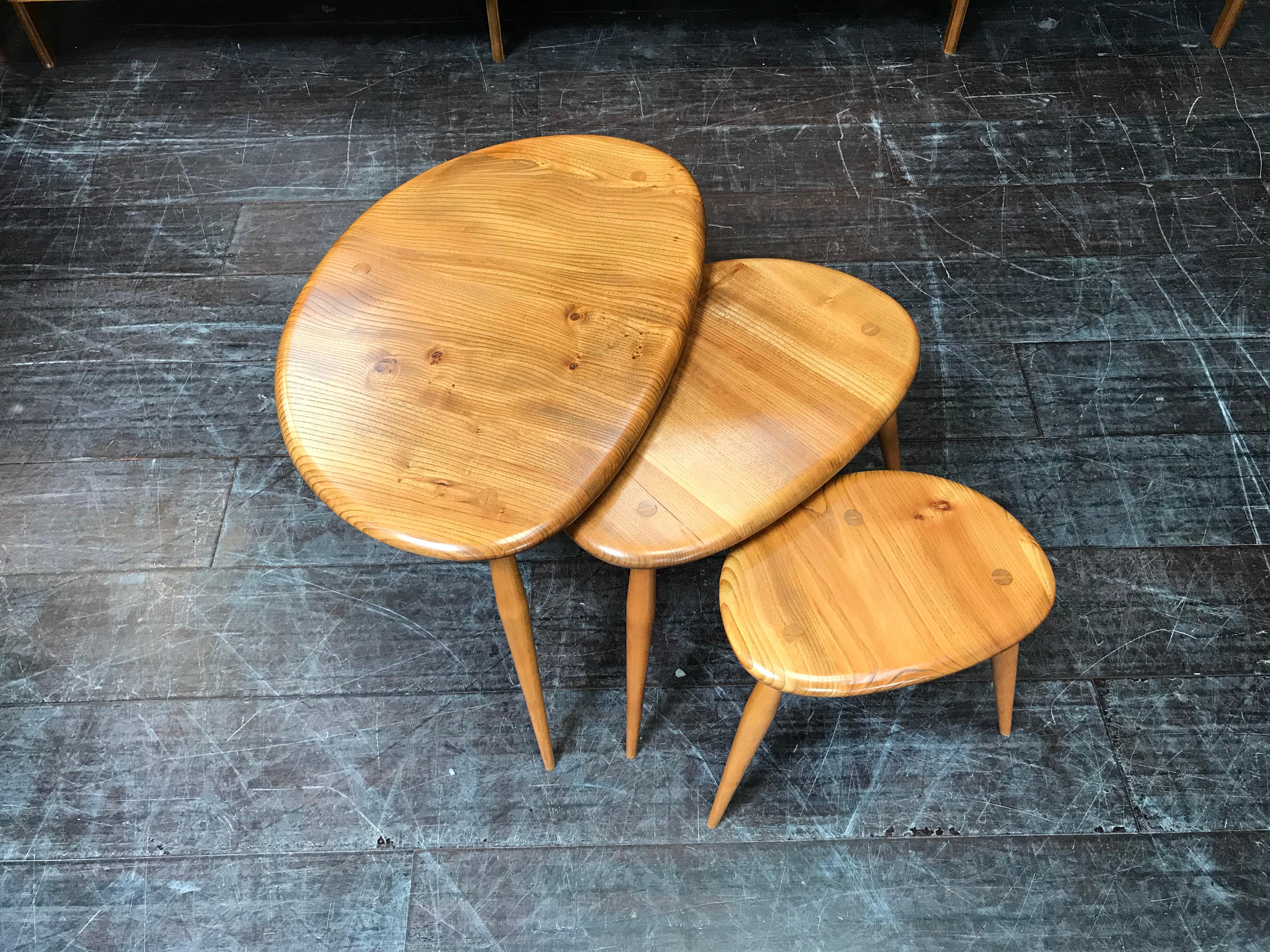 This nest of three tables, known as ‘Pebbles’, has been handcrafted from solid elm and beech. They represent iconic midcentury design, with their organically-curved pebble shaped tops and three distinctive slender, splayed legs. These Pebbles are a