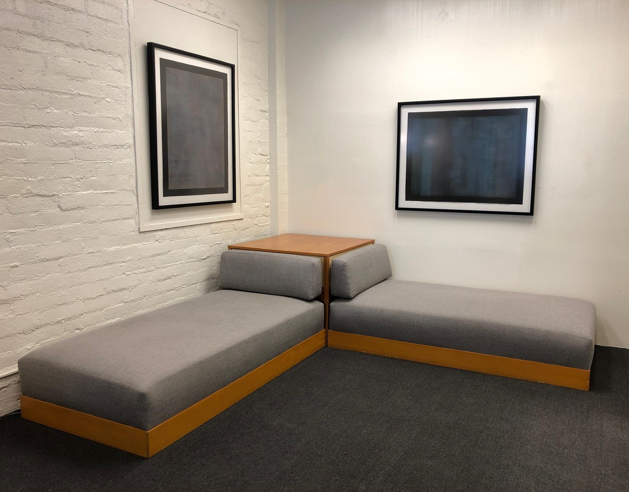 Rare set of daybeds with corner table by Herman Miller.
The wood is in original condition, so it shows some wear consistent with age.
It was re-covered  at one point. The fabric is light gray.
The beds retain original Herman Miller tag.