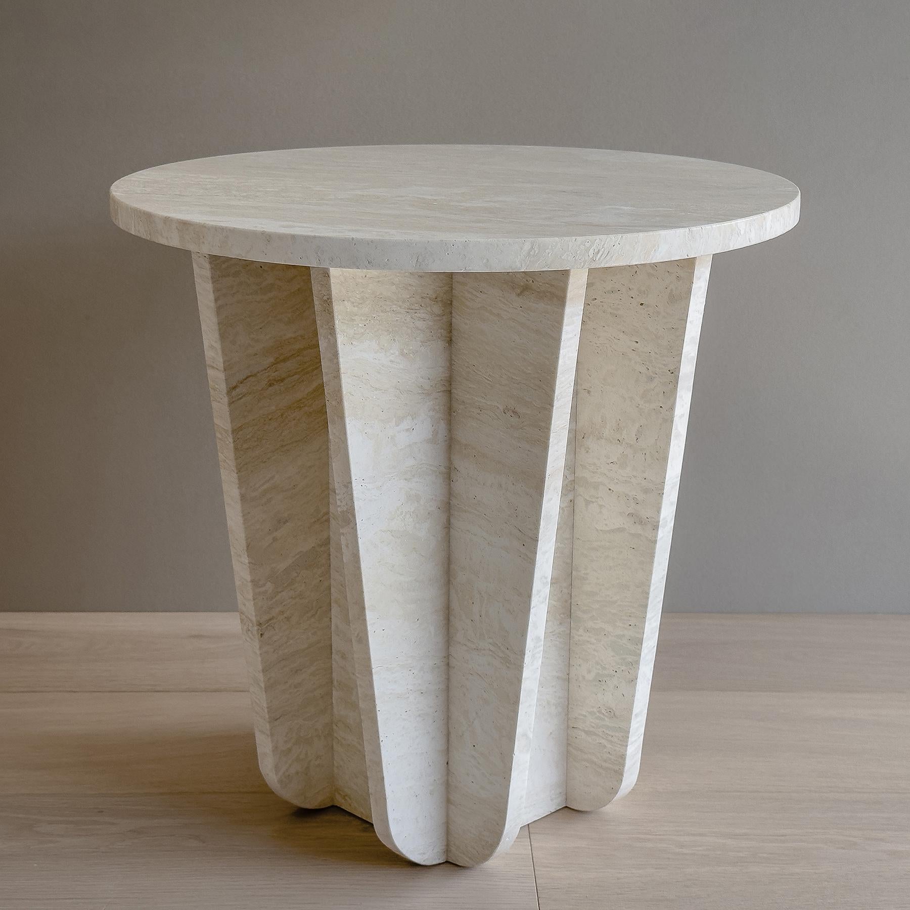 The BLOOM Table is crafted from white Italian travertine and features a tapered and curved structure, giving it an elegant and timeless look. Its minimalist design is perfect for any living space, while its sturdy construction makes it a reliable