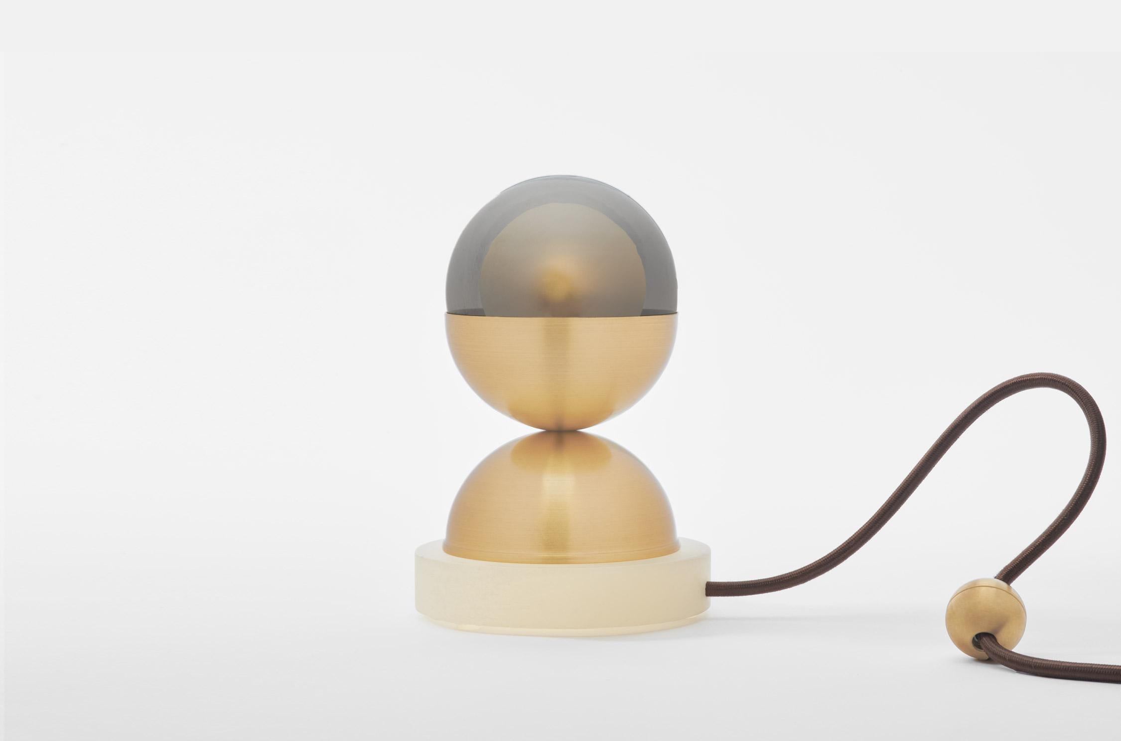 The bloom table Lamp's igenious design consists of glass, metal, and marble parts. The double glass orb (our Kadur pendant) rests inside a metal half-sphere, which is in turn balanced on another metal half-sphere attached to a round marble base. The