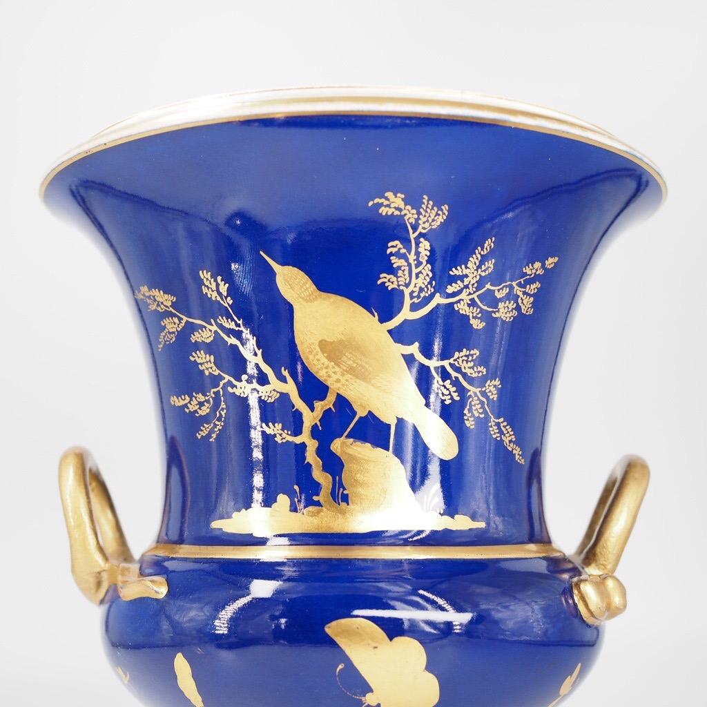 Bloor Derby urn, the deep blue ground decorated by Dodson with gilt birds and butterflies in silhouette, their details finely tooled, the handles shaped
 as serpents. 
Red crown & D mark, 
c.1825.