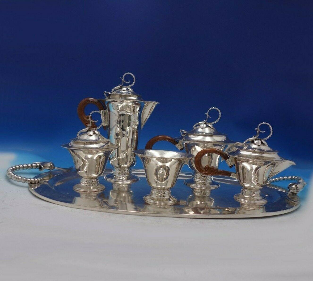 Blossom by Louvre Silver Shop

Stunning Blossom by Louvre Silver Shop Mexican sterling silver six-piece tea set featuring wood handles. This set includes:

1 - Coffee Pot: Measures 12