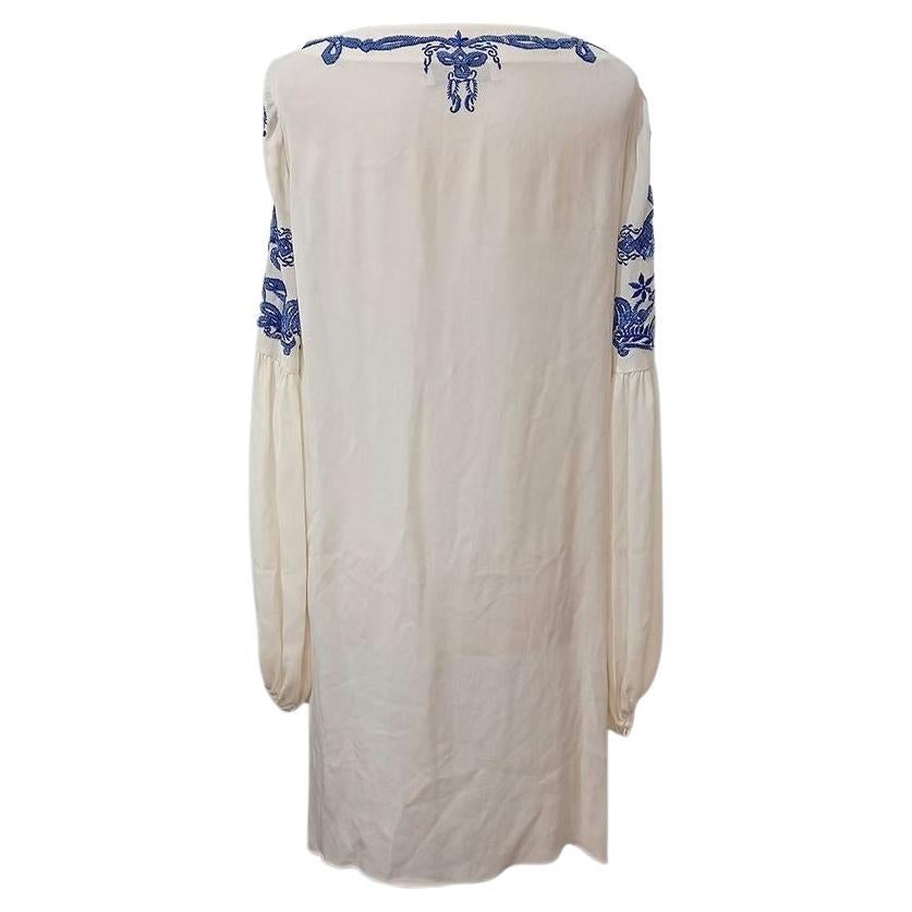 Seta Colore bianco crema Manica lunga e larga Impreziosita da ricami blu e perline Scollo a barca Con cintura (non in foto) Lunghezza totale cm 90 (3543 pollici)
