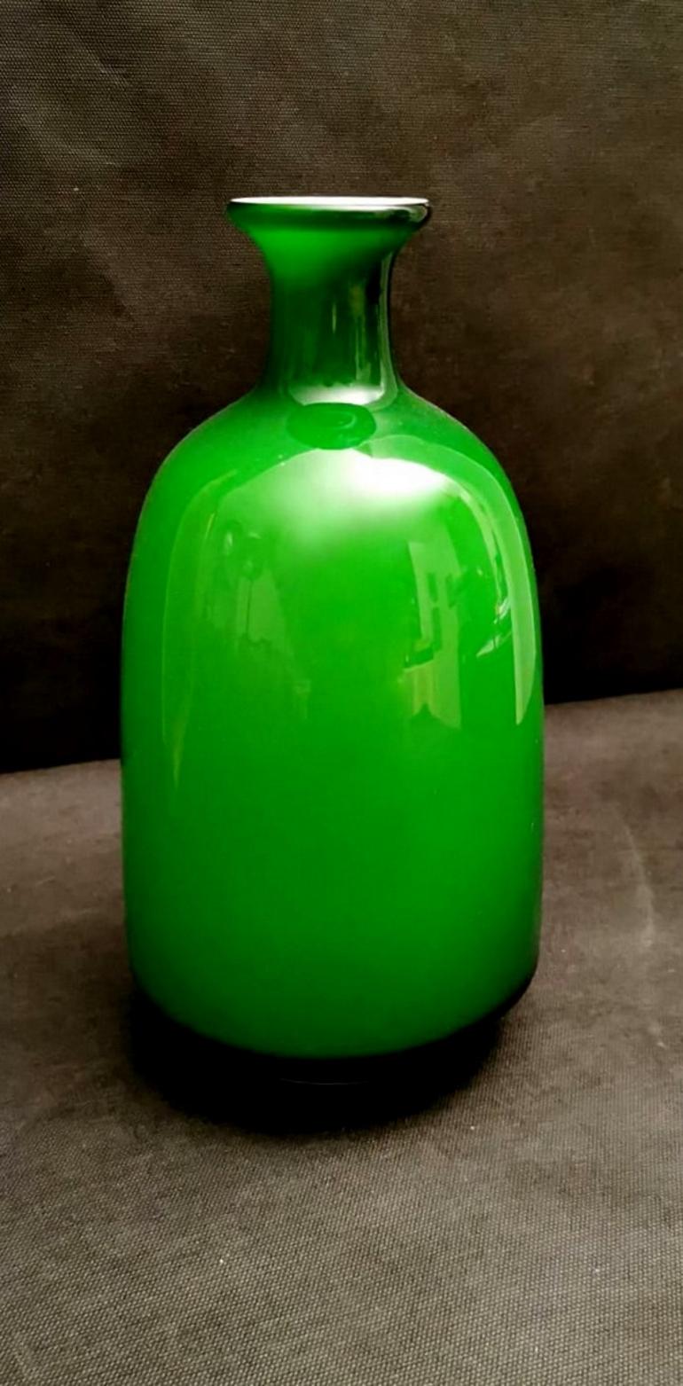 Green glass vase and white interior; the design is linear and simple but very proportioned and elegant; pleasant also the shade of green, remember that this color is frequently associated with hope, rebirth, spring, youth, meditation and calm and,