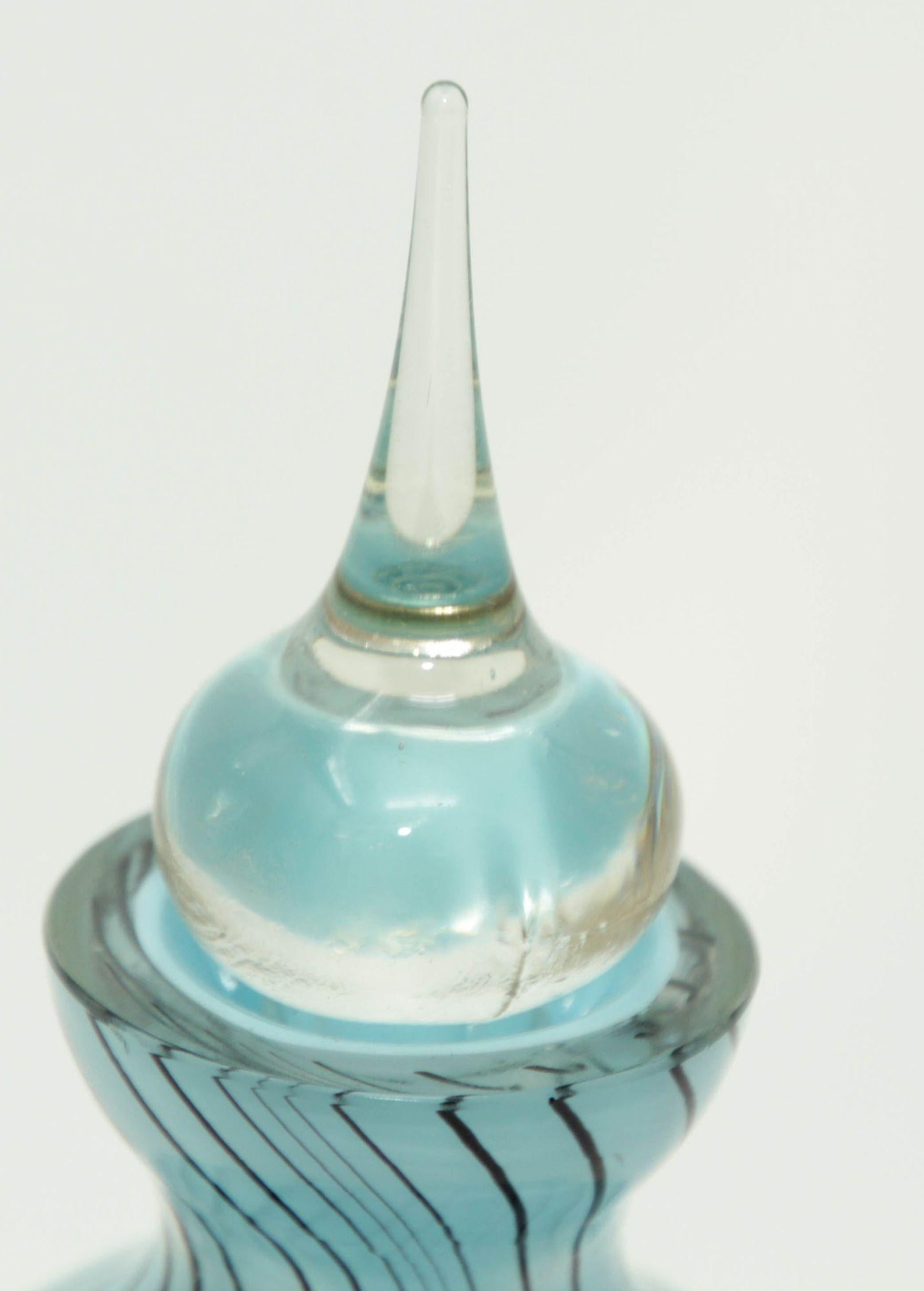 Flacon de parfum vintage en verre d'art de Murano avec bouchon d'origine en bleu ciel clair avec des rayures noires et un bouchon transparent.
Verre soufflé à la bouche en bleu et noir.
Le flacon de parfum est muni de son long bouchon d'origine avec