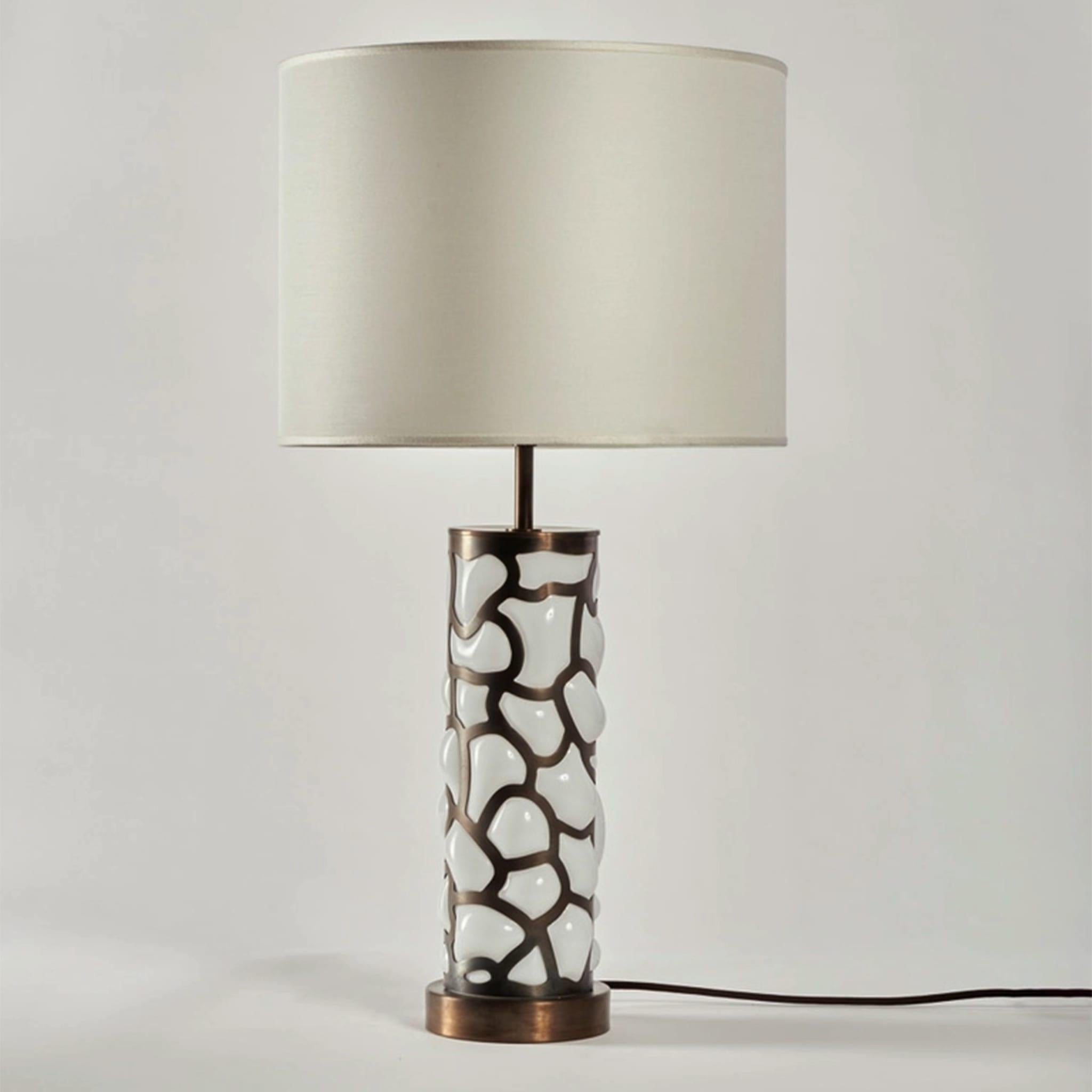 The table lamp from the Blown collection combines advanced laser cutting technologies and the thousand-year-old practice of Murano glass blowing. Its brass cage structure with a cloud pattern is complemented by Murano glass blown inside, thus