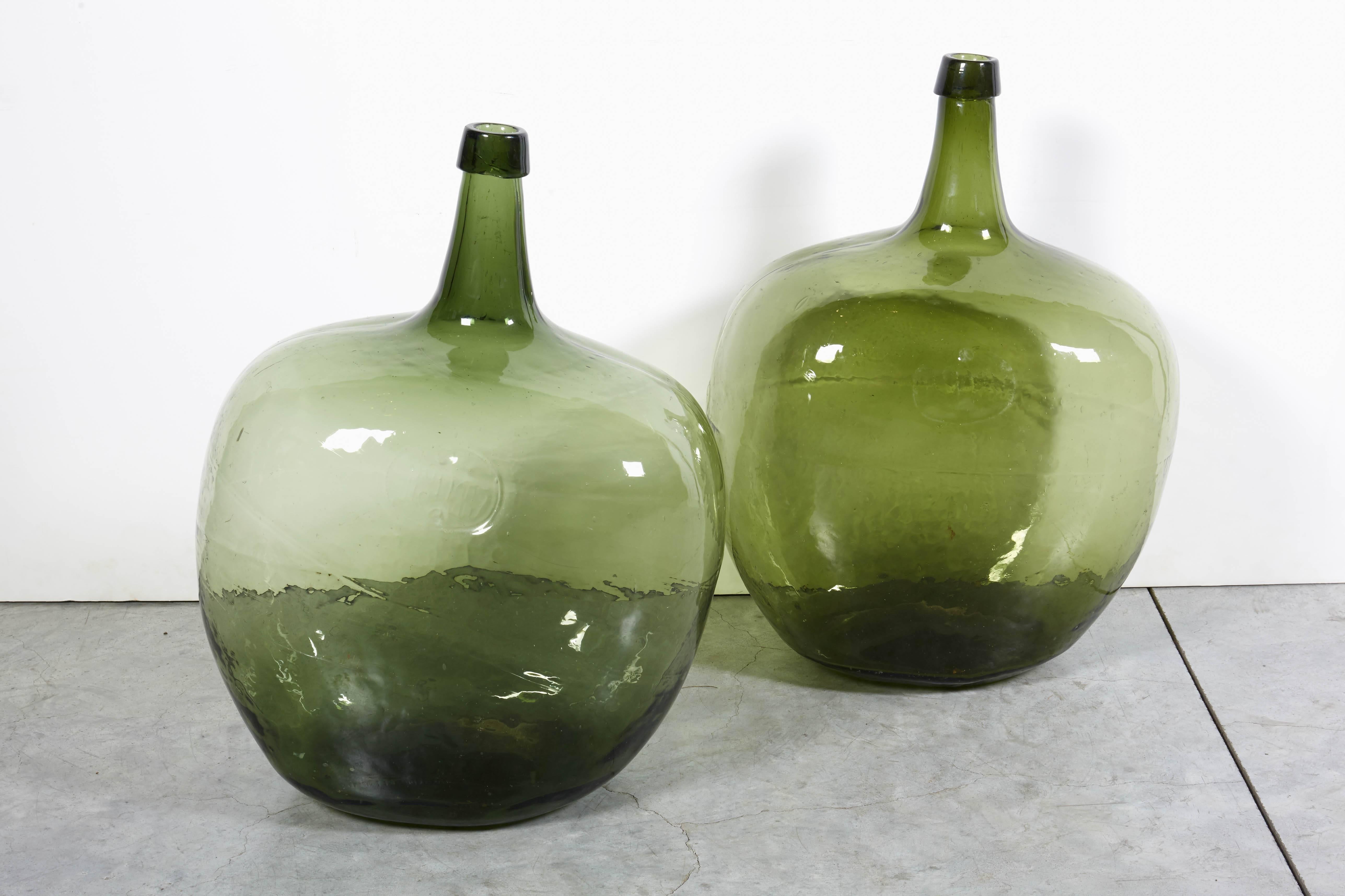 Two beautifully shaped blown glass 19th century demijohns with rough pontils and applied lips. Striking green color, France, circa 1880.
GL225.
