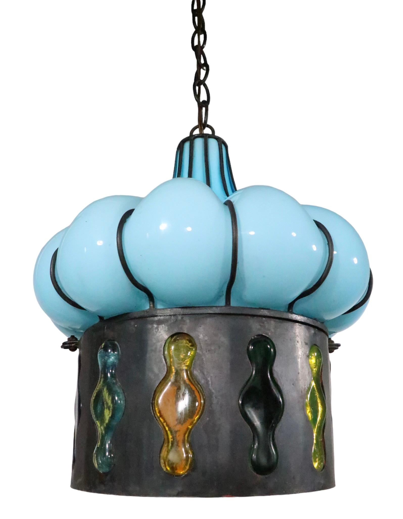Probably the best blown glass and metal pendant light we have had the pleasure of offering, this fixture features a baby blue upper section, with a mosaic like lower section, which has multi colored glass panels. The chandelier is in excellent