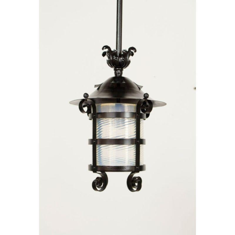 Victorian gas lantern with original mouth blown swirled blue tinted glass. Iron fram is painted black as are all metal parts. Glass is a cylinder. Restored, repainted and rewired for exterior or damp location. Single standard bulb.

Dimensions: