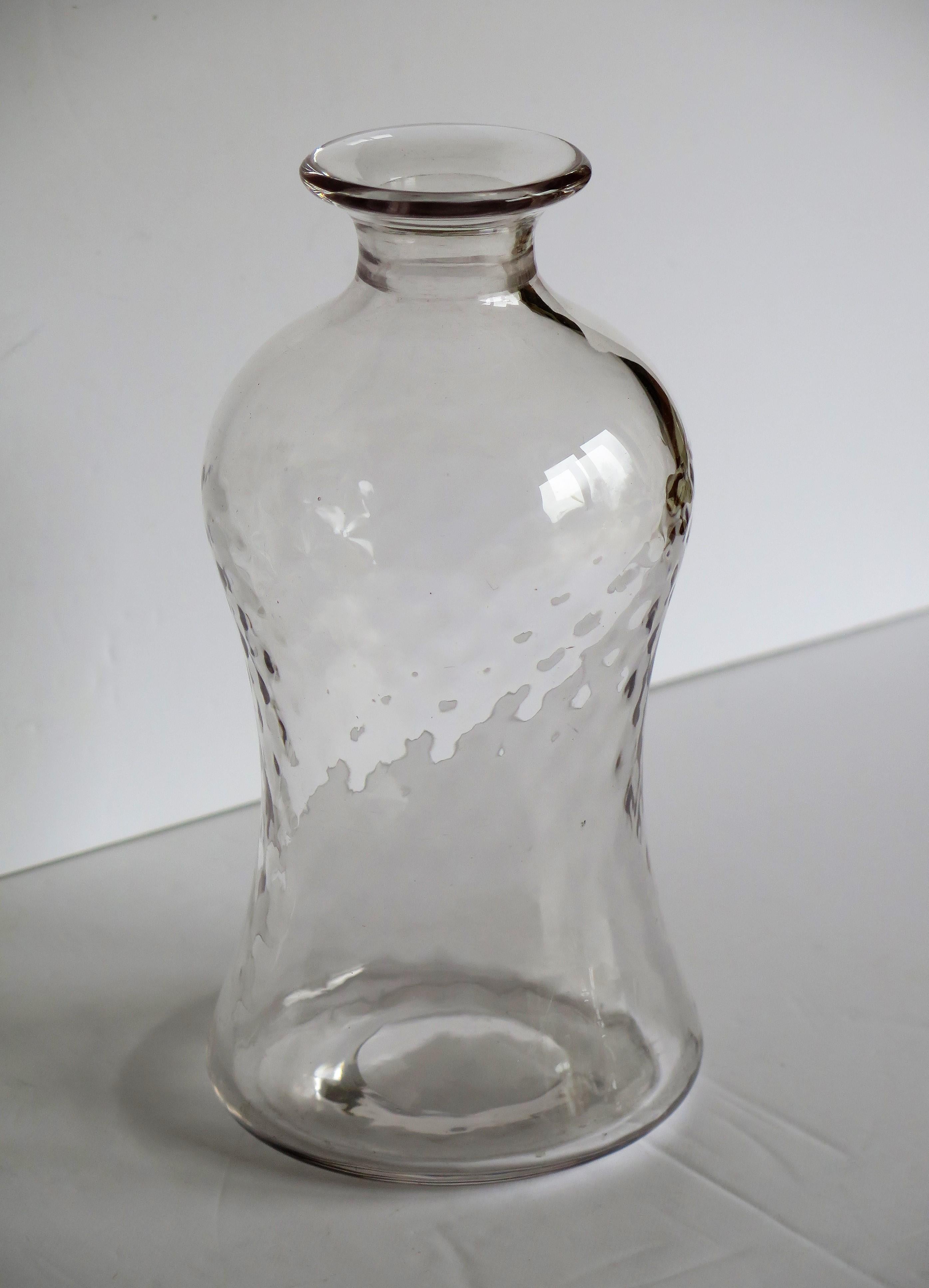 This is a good cut-glass or crystal decanter or wine carafe, hand blown with a waisted shape and dimple moulded decoration with its original mushroom stopper, made of heavy lead glass, and dating to Edwardian England, circa 1900.

This hand blown