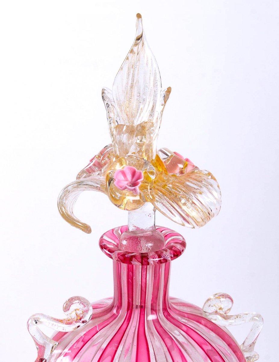 Blown glass perfume bottle - Murano
Perfume bottle in pink blown glass resting on a circular foot with gold glitter.
This bottle comes from the Murano glassworks.
First third XXth century.
Dimensions: Height: 28,5cm x Diameter: 8cm.
