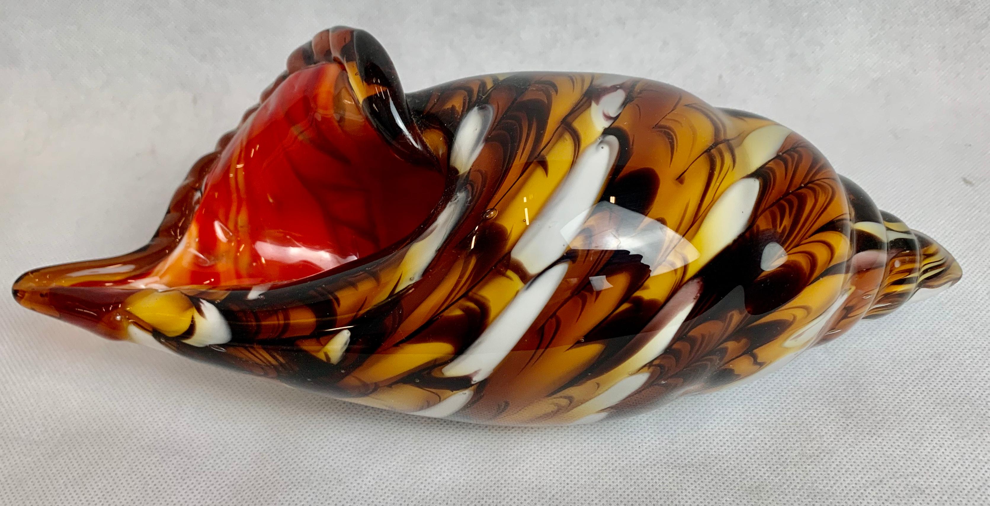 Blown glass shell vase in shades of brown caramel, ivory with a red interior. This piece is triple cased which means the red colored glass is layered with the brownish glass and finally a layer of clear glass. The shell itself has a ground base to