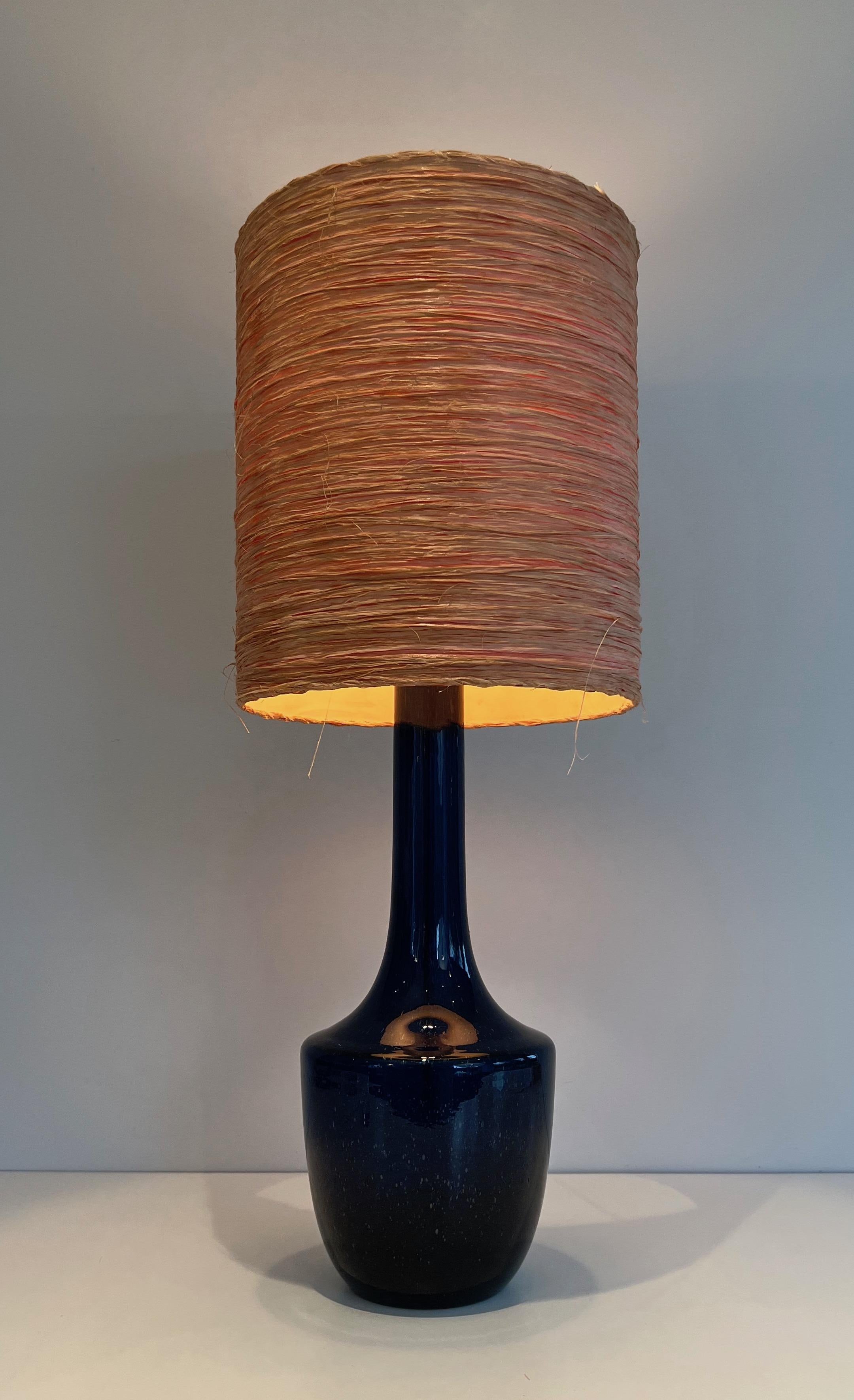 This very nice table lamp is made of blown blue glass with a raffia shade. This is a French or Italian work. Circa 1970