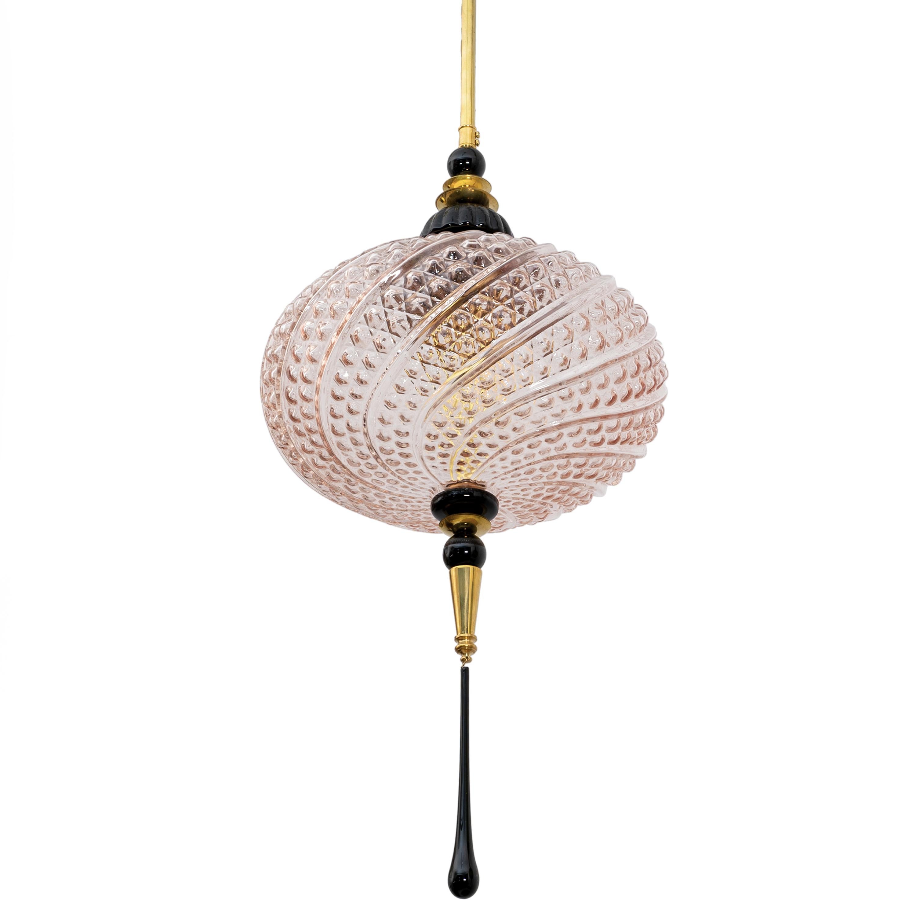 Un lampadario a lanterna in stile orientale contemporaneo, interamente realizzato a mano in Italia, qui presentato con elementi in ottone. La sfera ovale organica è realizzata in un innovativo vetro di Murano soffiato a mano, rosa e strutturato con