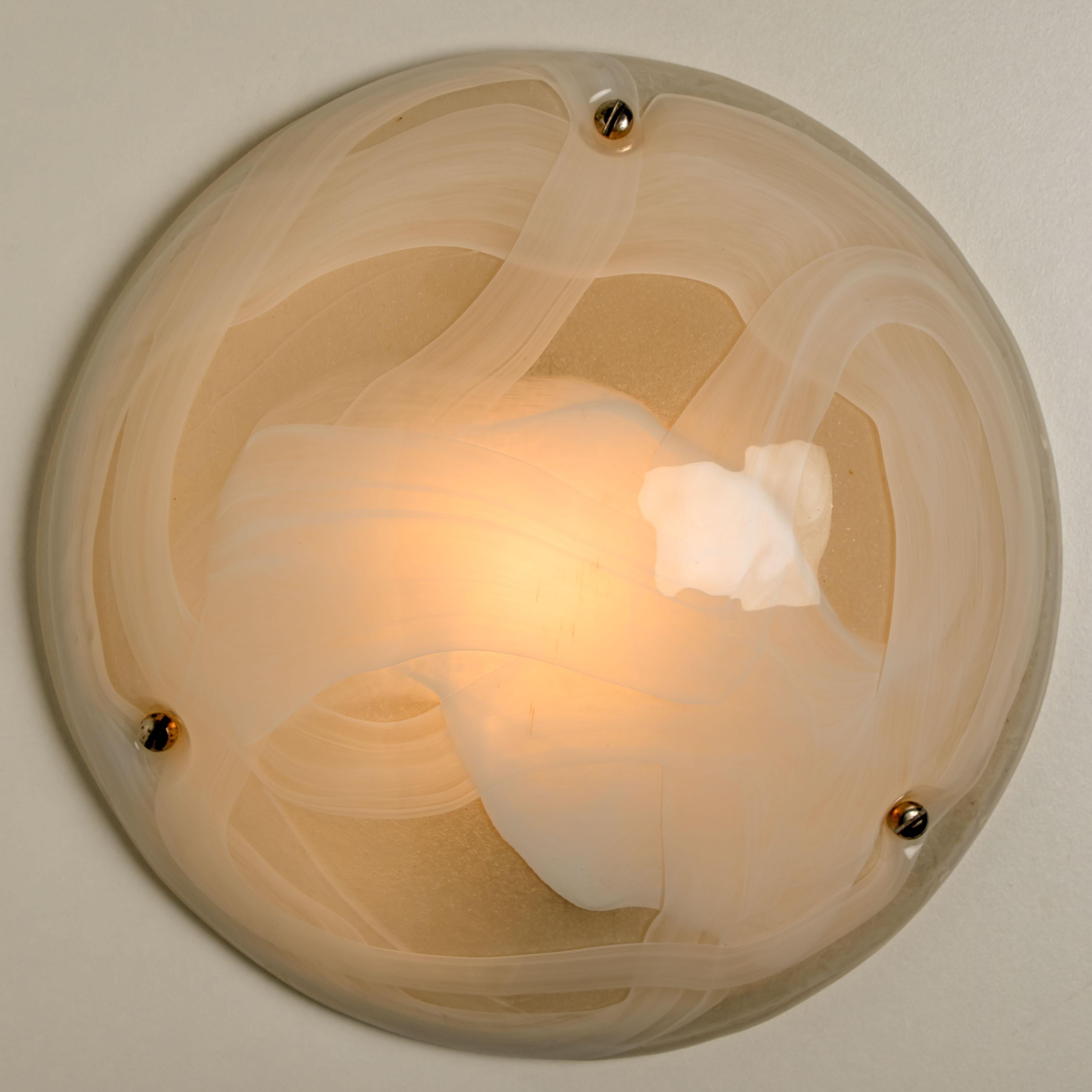High-end murano glass wall lights or flush mount. The brass ring holds a large heavy blown glass with three brass brackets. The think glass has a beautiful textured structure. With clear and milky-white glass and white back plate. Beautiful